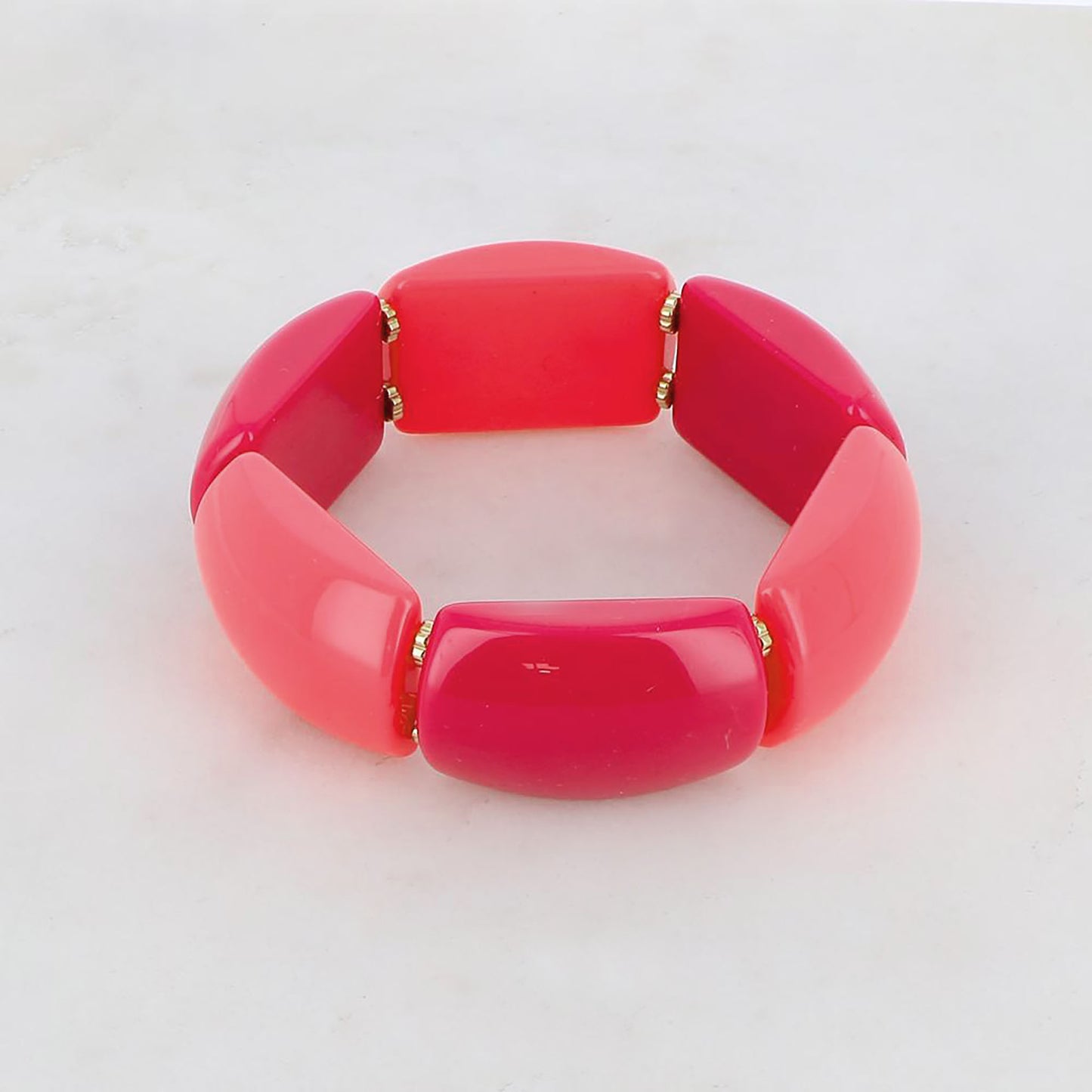 Elastic bracelet in shades of pink with polished segments and gold spacers, French brand Ikita.
