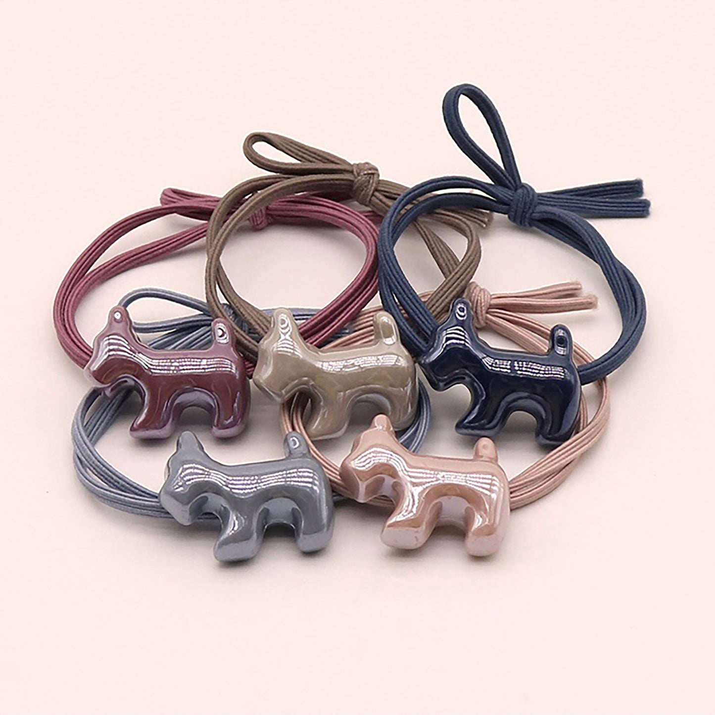 Gray hair tie with a glossy dog-shaped charm.