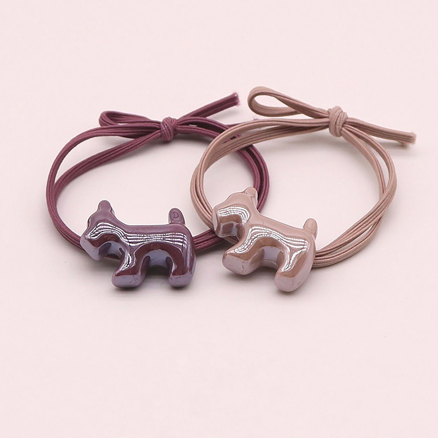 Purple hair tie with a glossy dog-shaped charm.