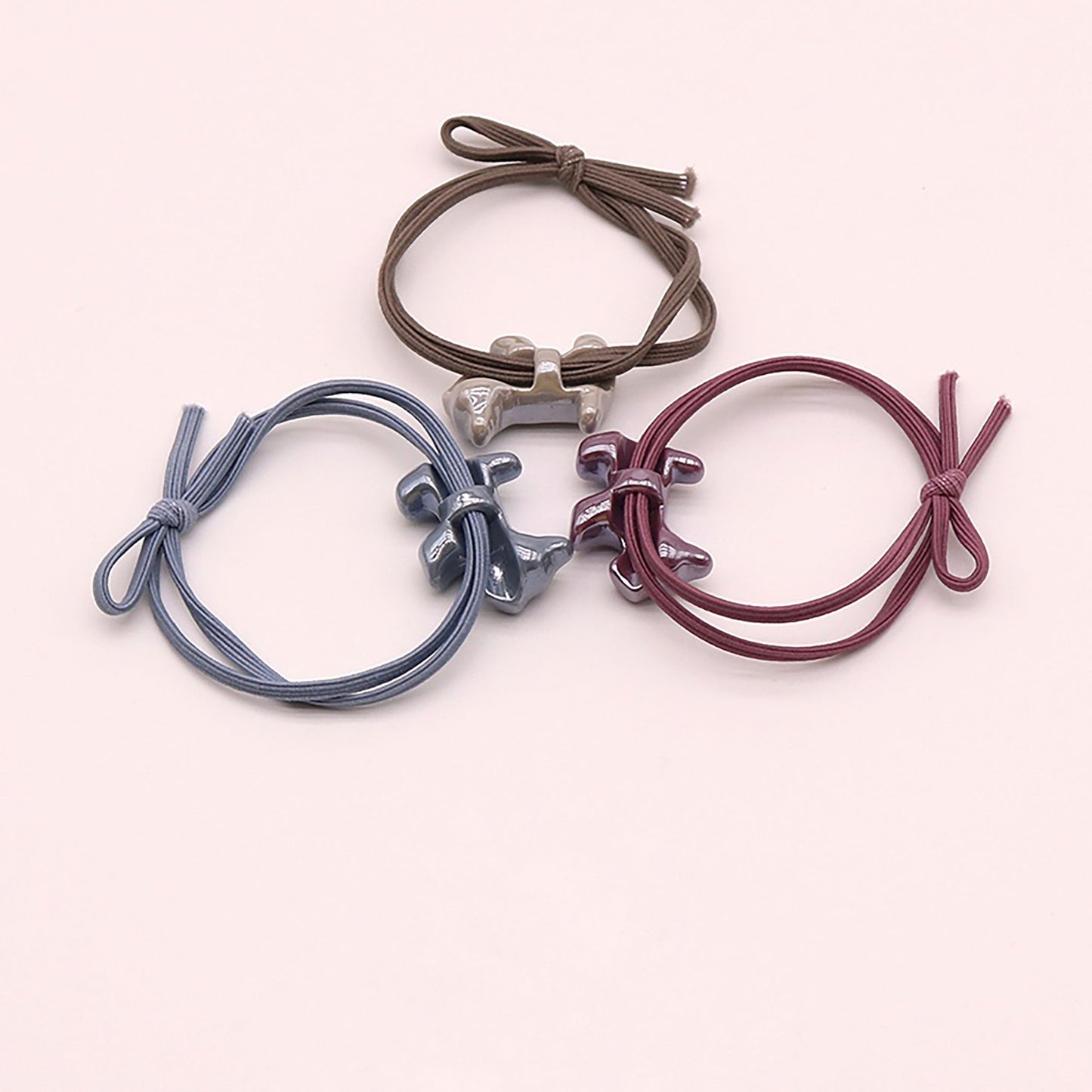 Élastique à cheveux violet avec un pendentif en forme de chien à finition brillante.