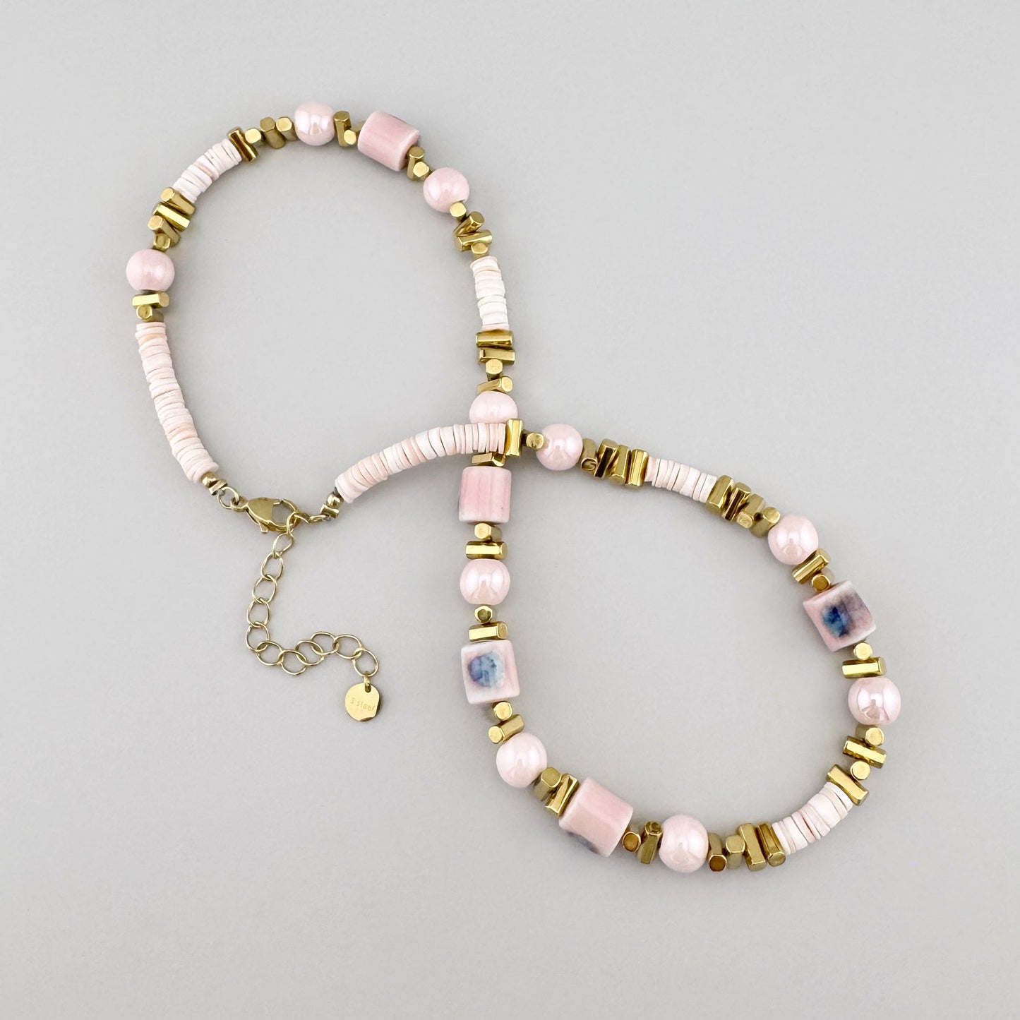 Necklace with powder pink ceramic beads and golden elements, French brand Ikita.