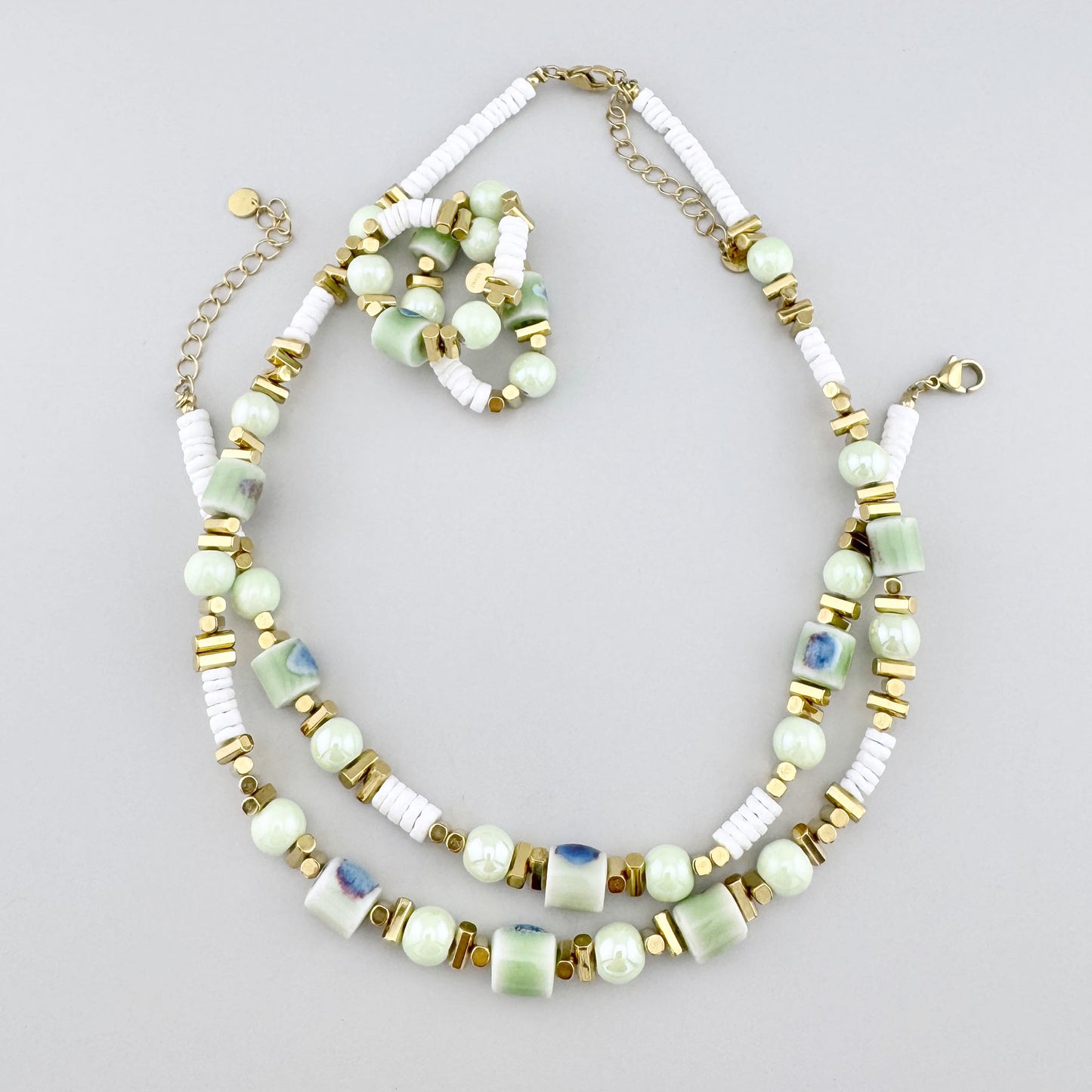 Bracelet élastique avec perles en céramique peintes à la main, dans des tons pastel de vert, bleu et bordeaux, marque française Ikita.