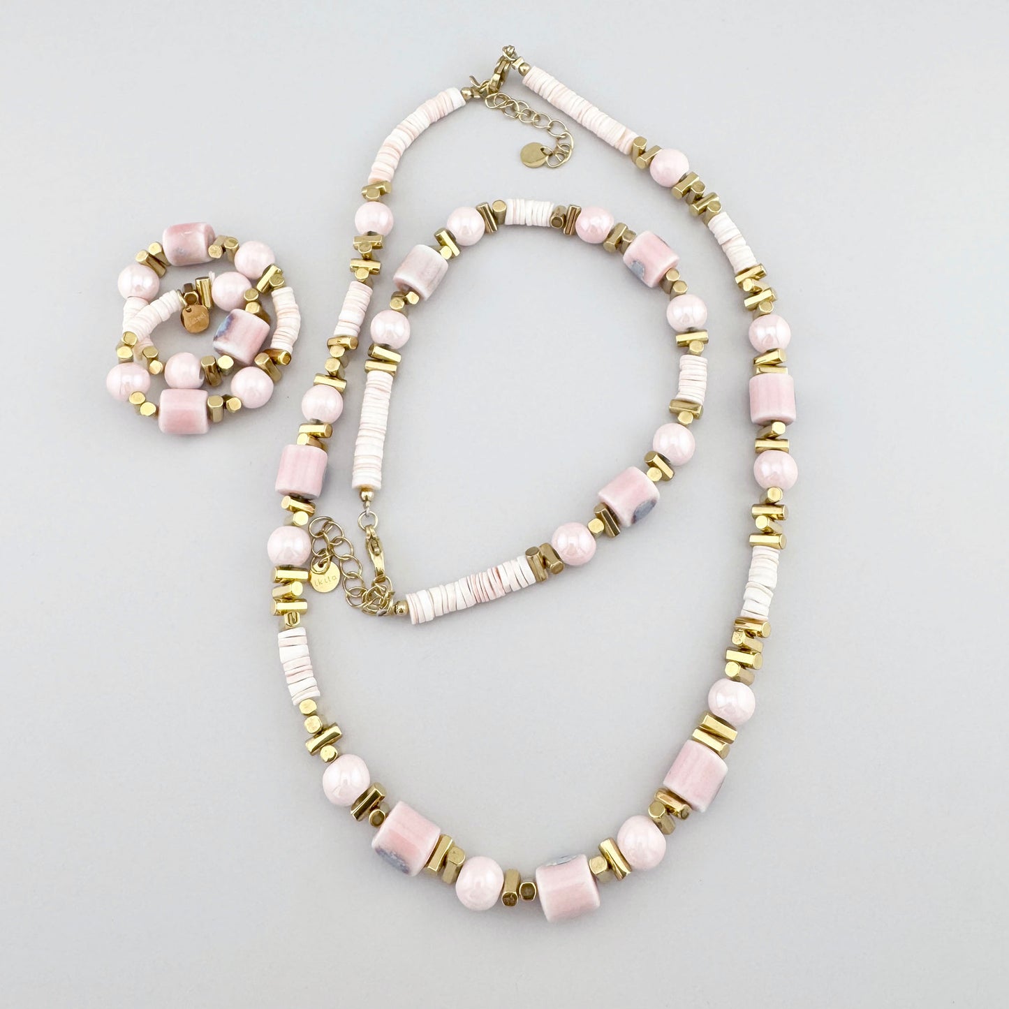 Fußkettchen aus Keramikperlen in Puderrosa-, Weiß- und Beigetönen, französische Marke Ikita.