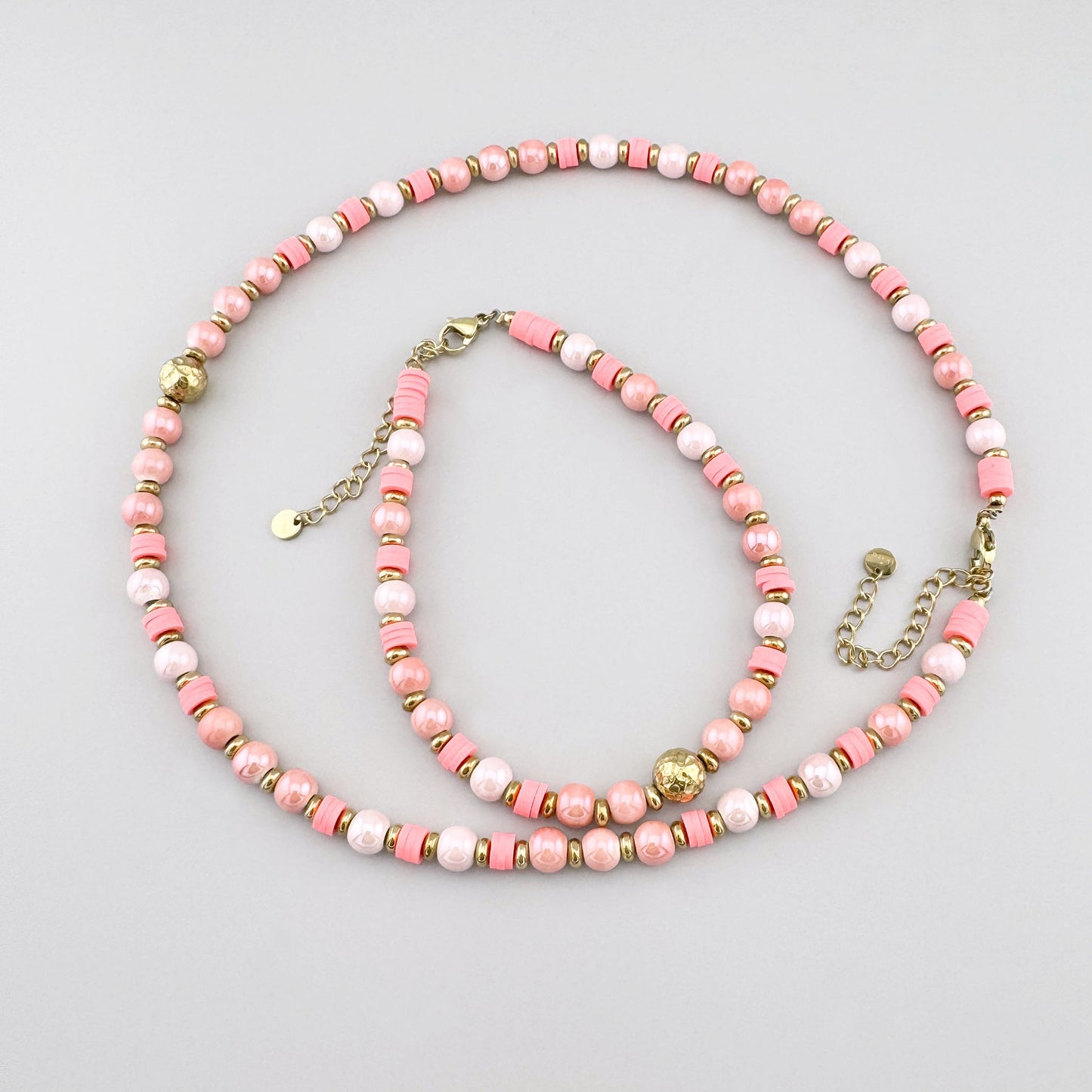 Collar con cuentas cerámicas rosadas tipo perlas y detalle dorado central, marca francesa Ikita.