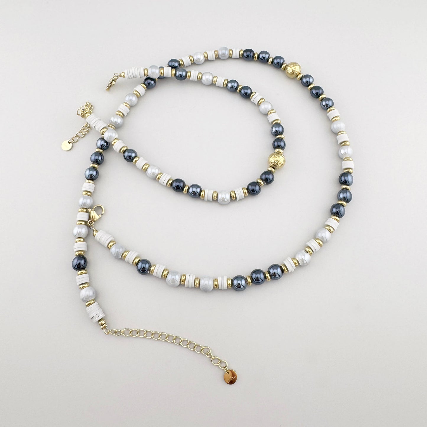 Collar con cuentas de cerámica en tonos blancos y grafito y detalles dorados, marca francesa Ikita.