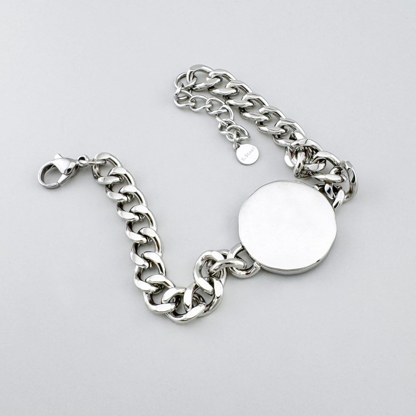 Pulsera de cadena en acero inoxidable con medallón plateado y dorado grabado con estrellas, marca francesa Ikita.