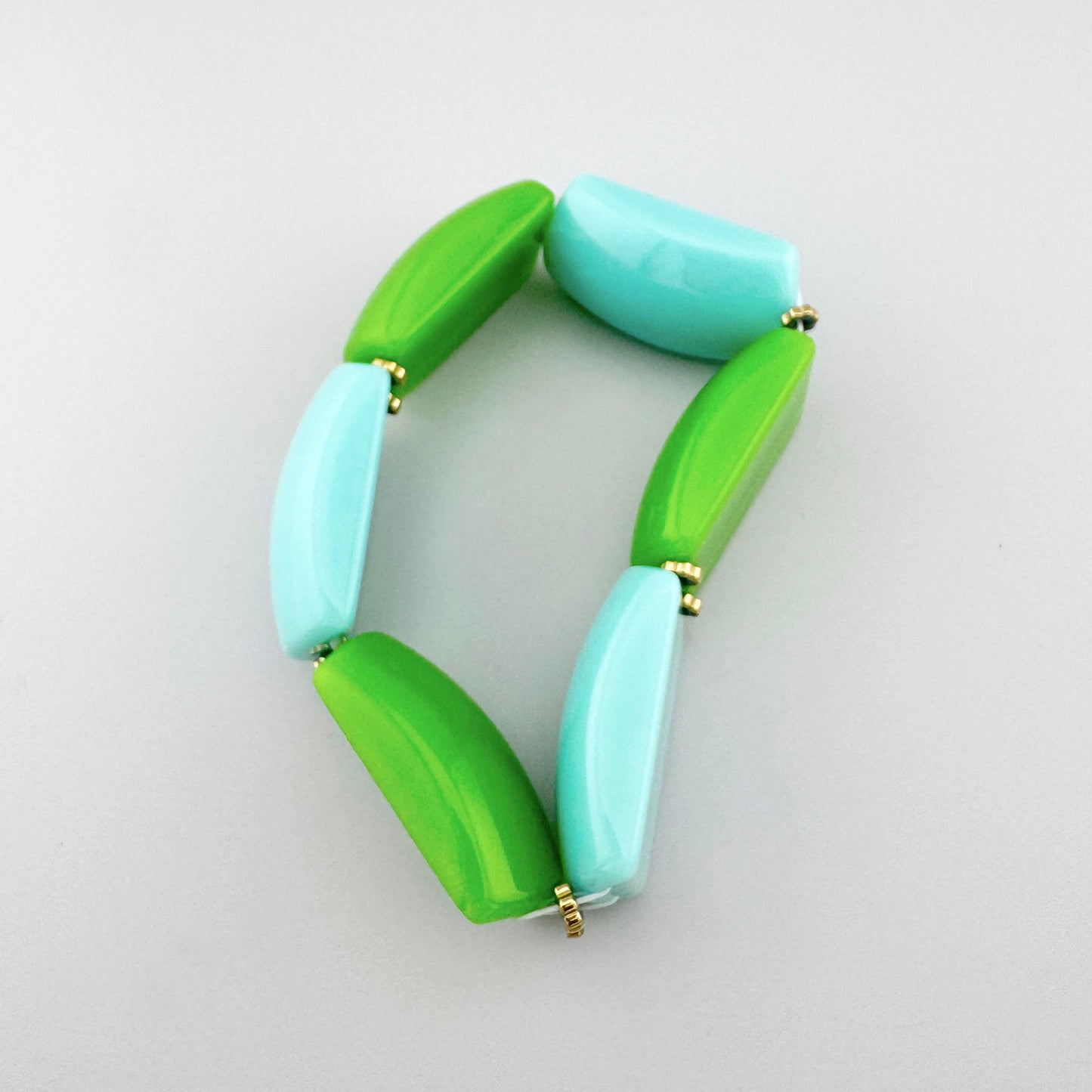 Bracelet en plastique aux tons verts et bleus avec éléments géométriques, marque française Ikita.