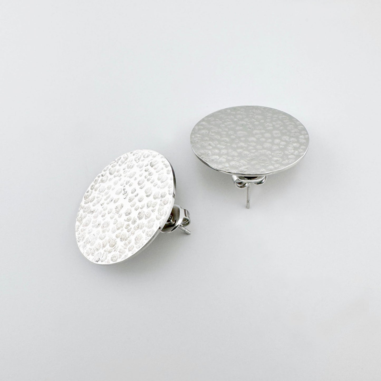 Boucles d’oreilles rondes en acier inoxydable argenté avec texture martelée, marque française Ikita.