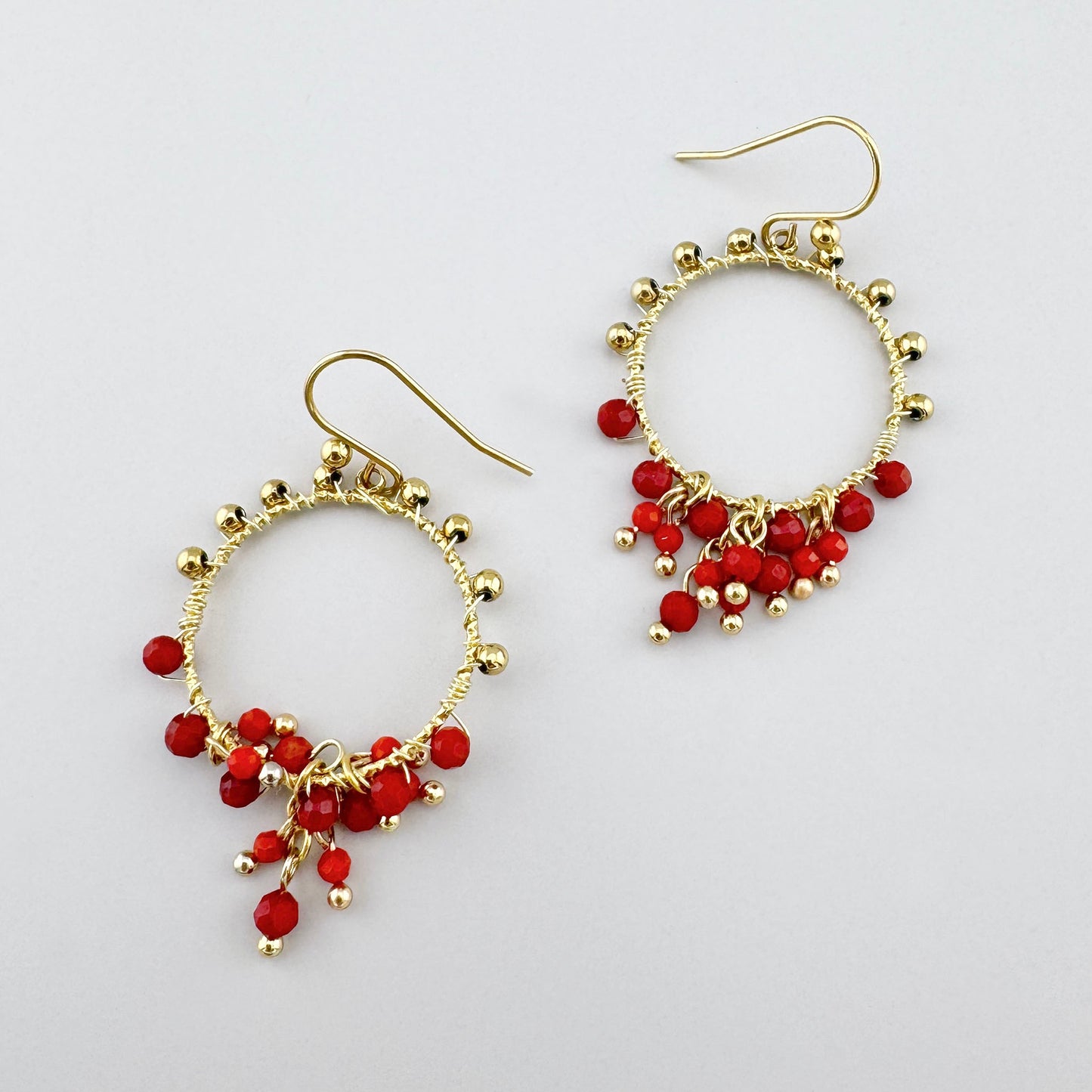 Kreisförmige Ohrringe mit roten Kristallen und goldenen Kugeln, französische Marke Ikita.