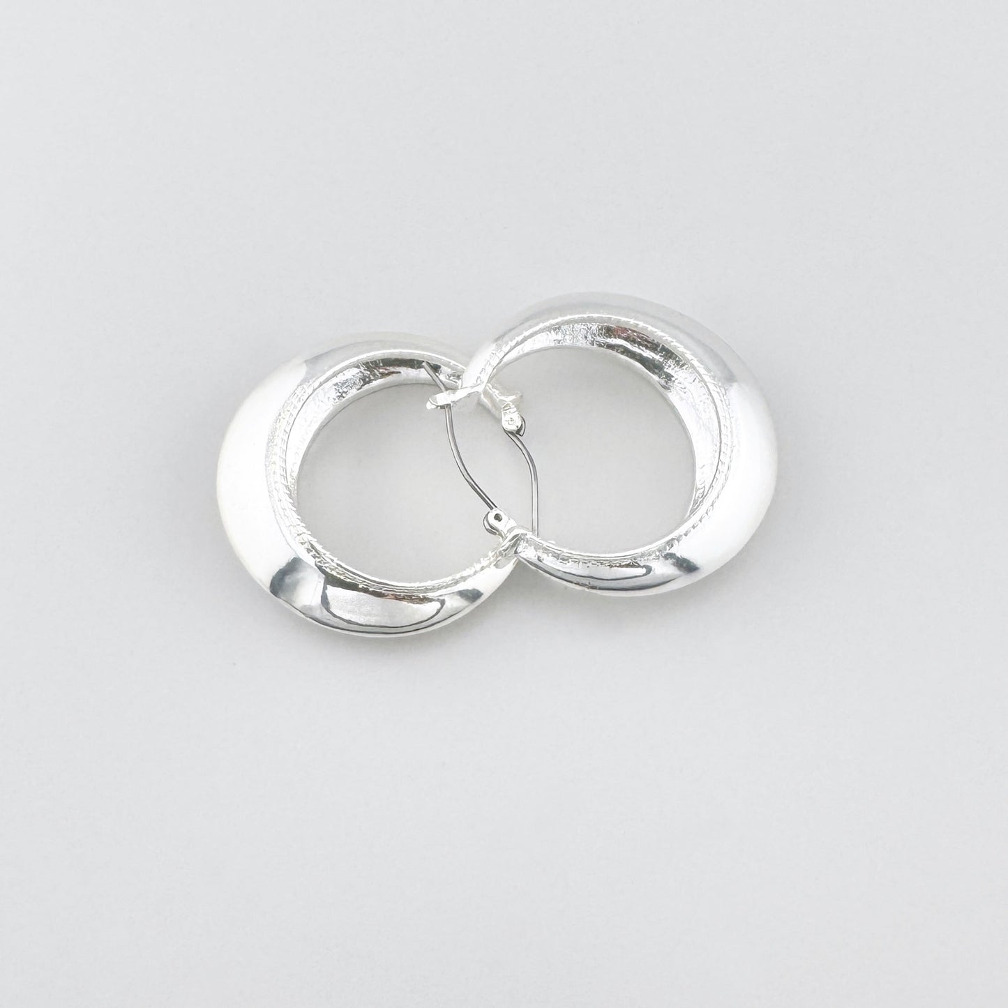 Boucles d’oreilles créoles larges à finition miroir, marque danoise Pilgrim.