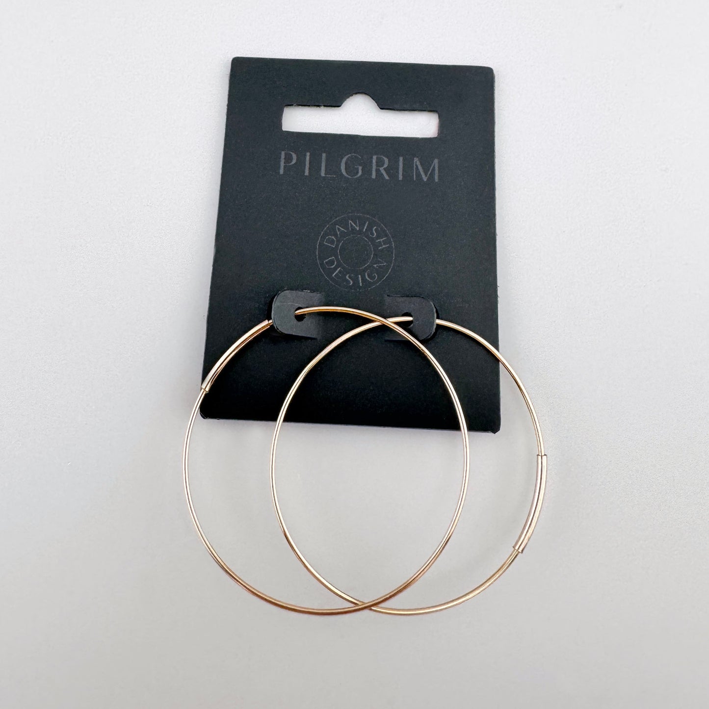 Goldfarbene Creolen aus dünnem Metall mit glatter Oberfläche, dänische Marke Pilgrim.