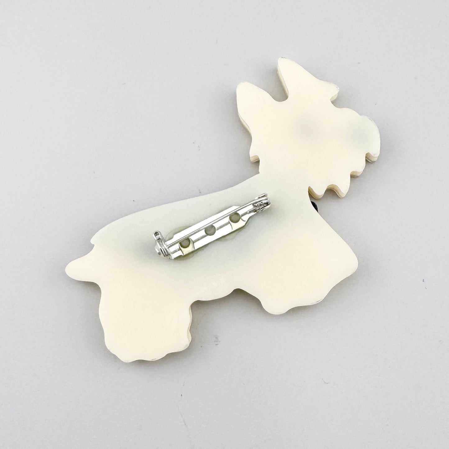 Brosche in Form eines Hundes aus perlmuttfarbenem Acryl mit Mosaikstruktur und gestreifter Weste, spanische Marke Sonata.