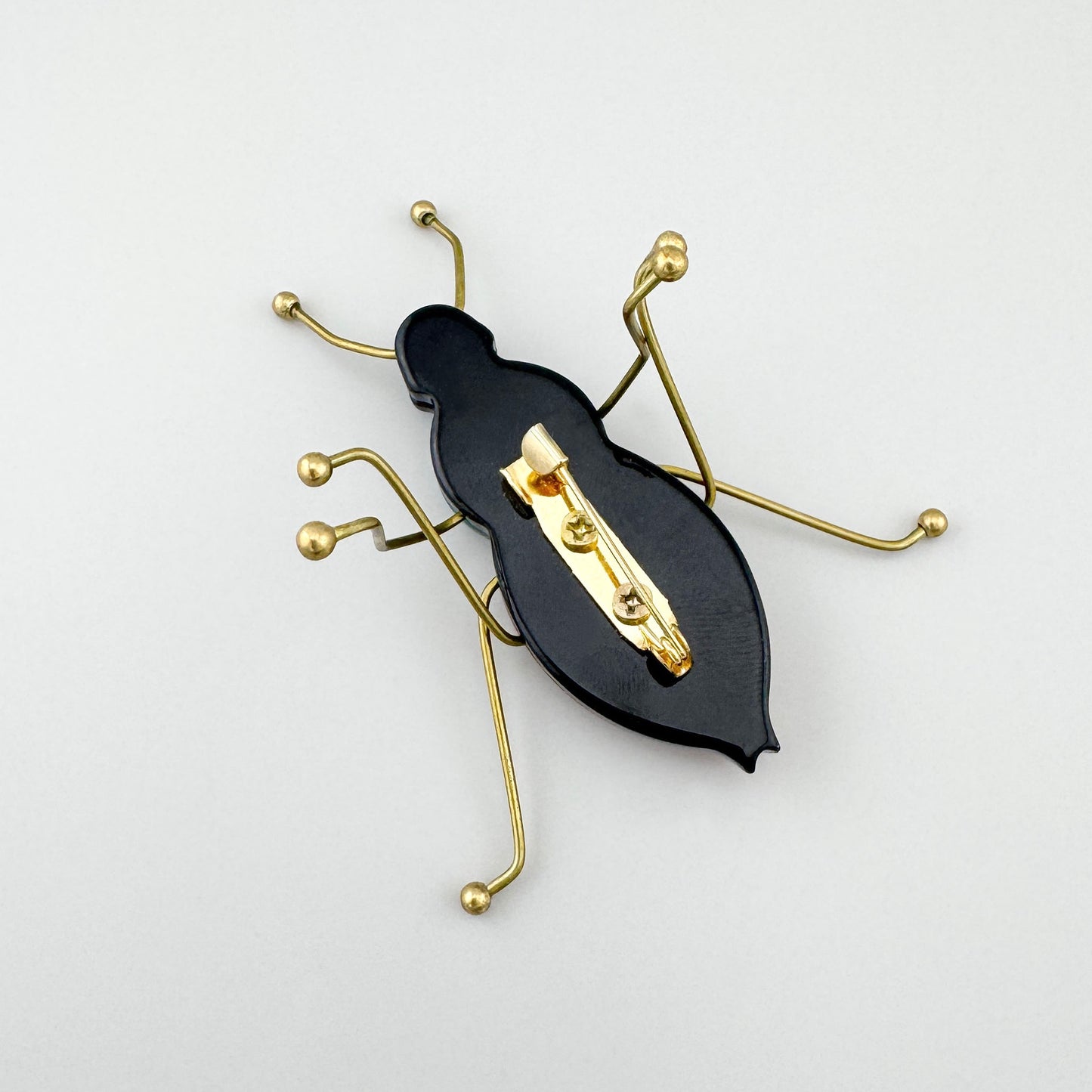 Brosche in Form eines stilisierten Insekts aus gefärbtem Acryl und goldfarbenem Metall, spanische Marke Sonata.