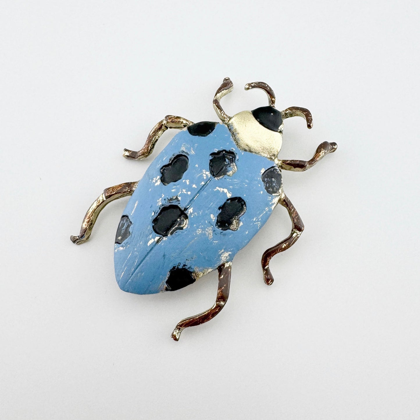 Originelle Käfer-Brosche aus Metall mit blauer Emaille und schwarzen Details.