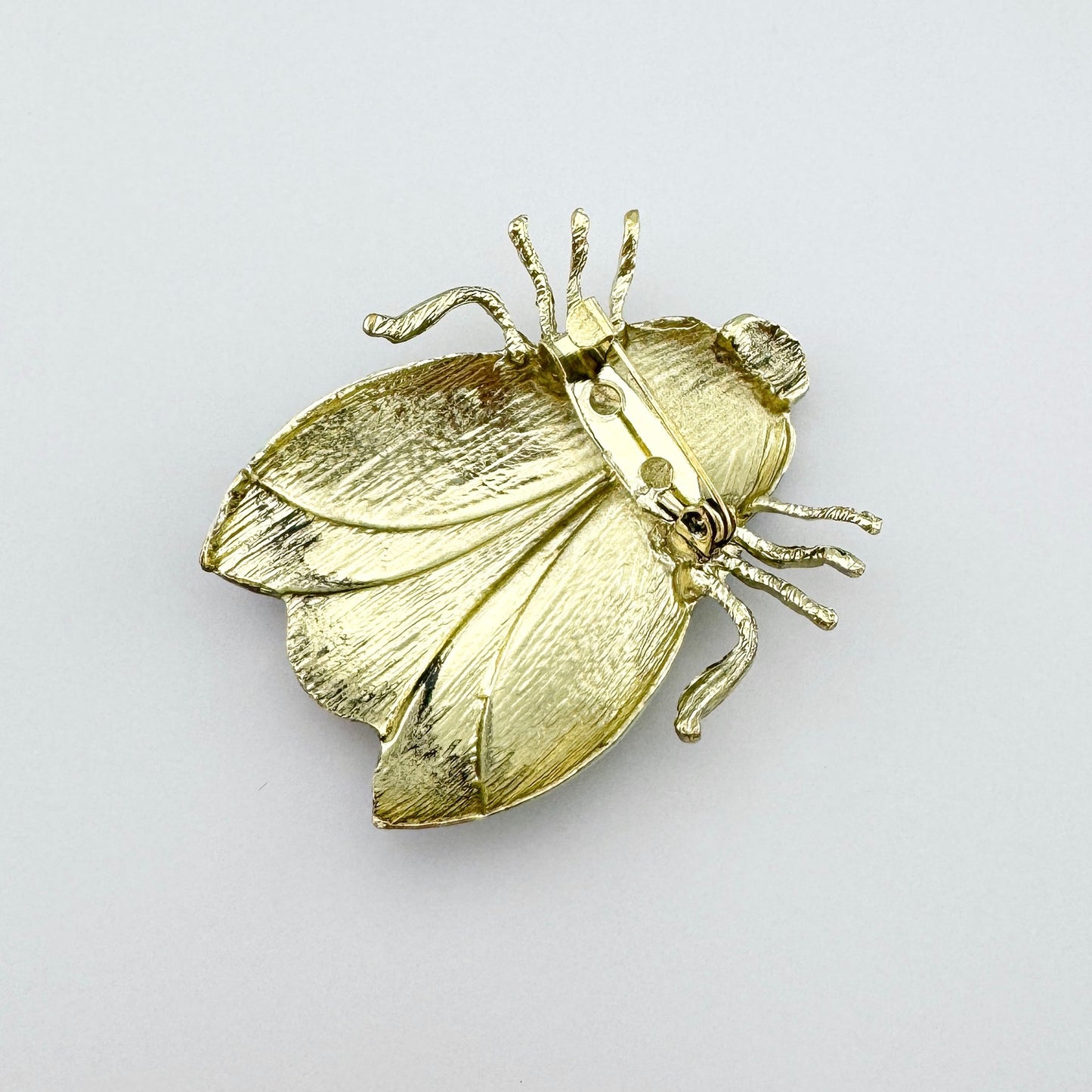 Broche con forma de insecto, pintado a mano con esmalte en tonos pastel de menta, rosa y marrón.