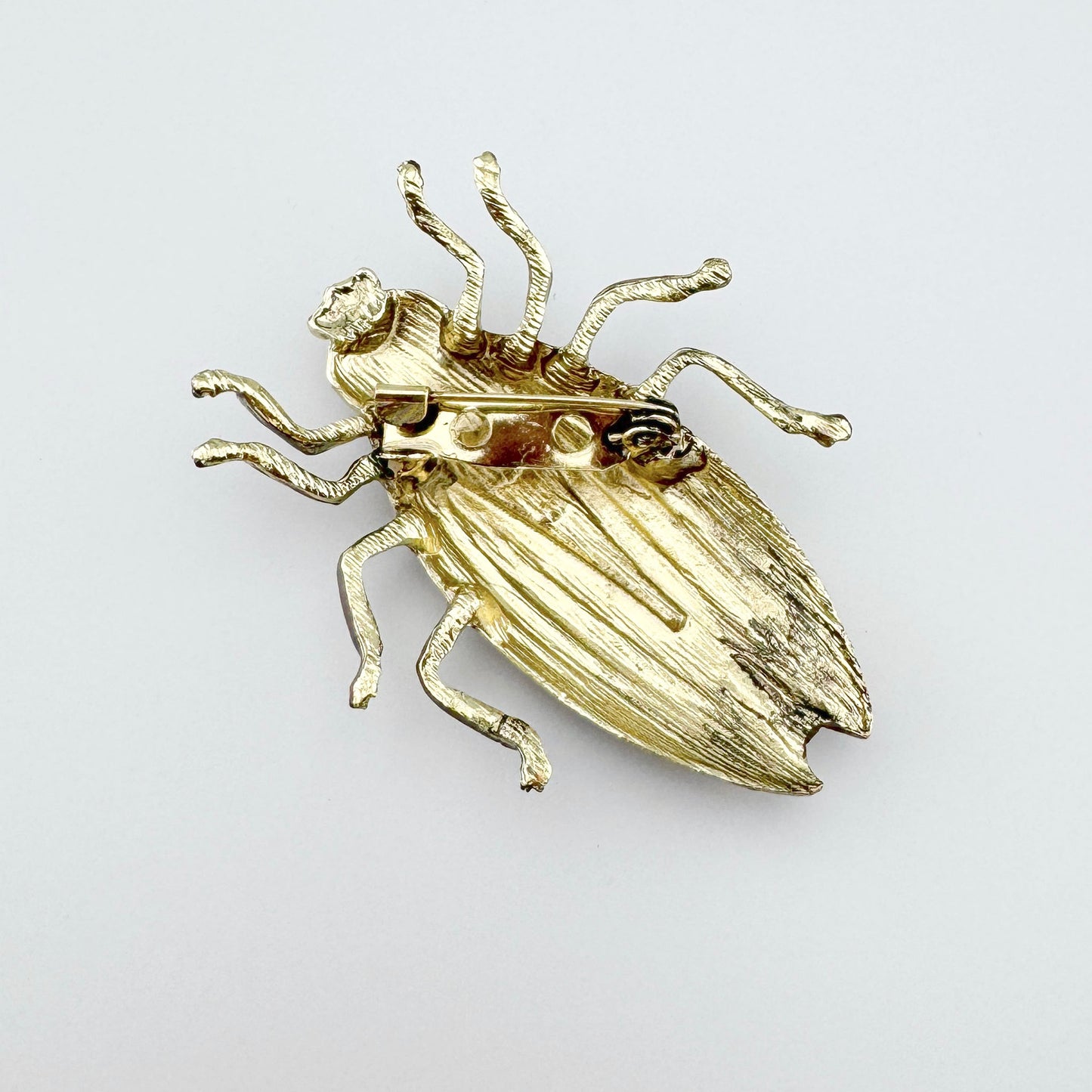 Insect-shaped brooch, hand-painted in pastel pink with black accents.