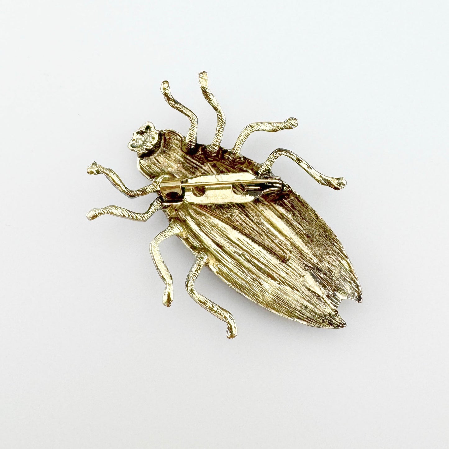 Broche en forma de escarabajo, hecho a mano en tonos rojos, negros y dorados.