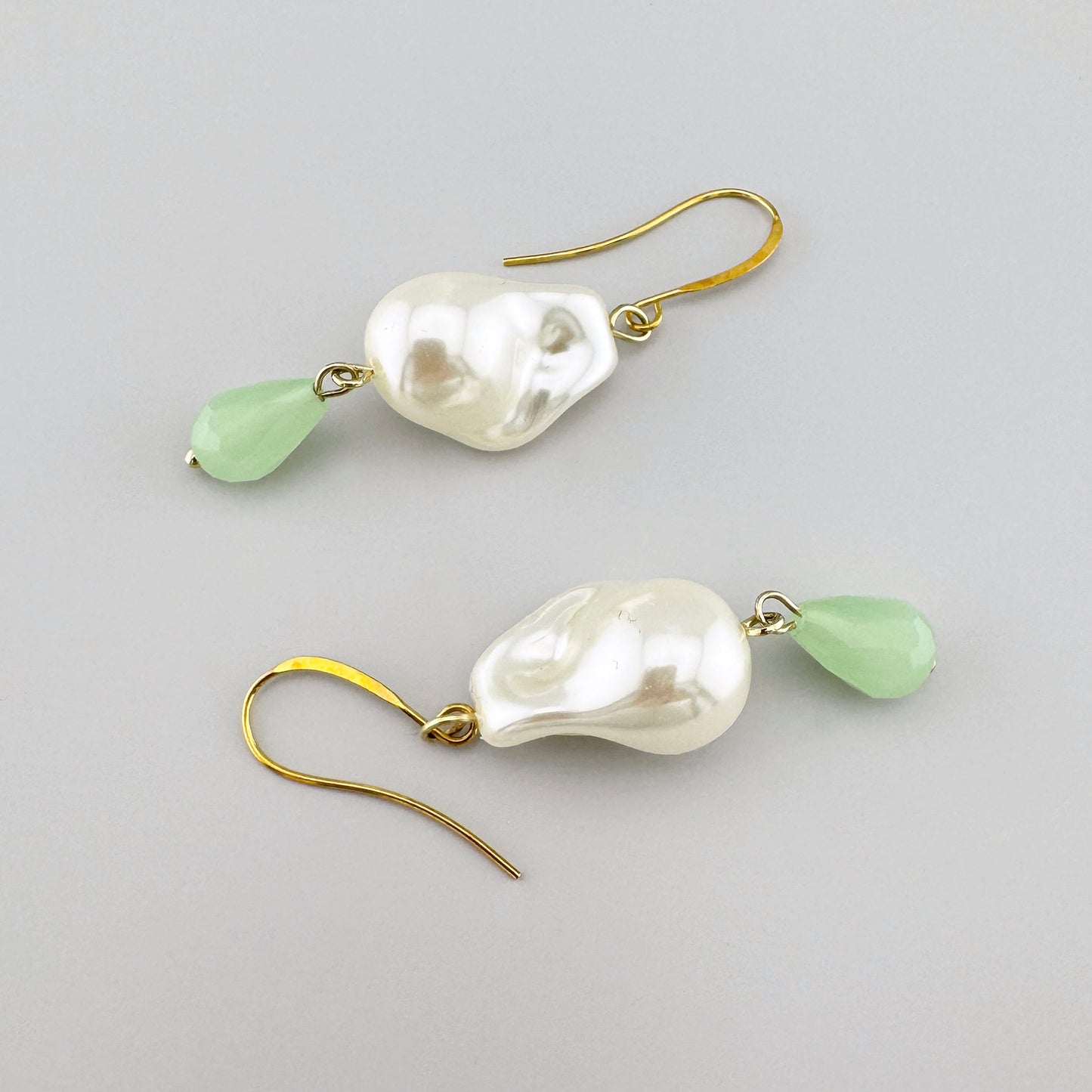 Pendientes con perlas artificiales estilo barroco y piedra verde facetada.