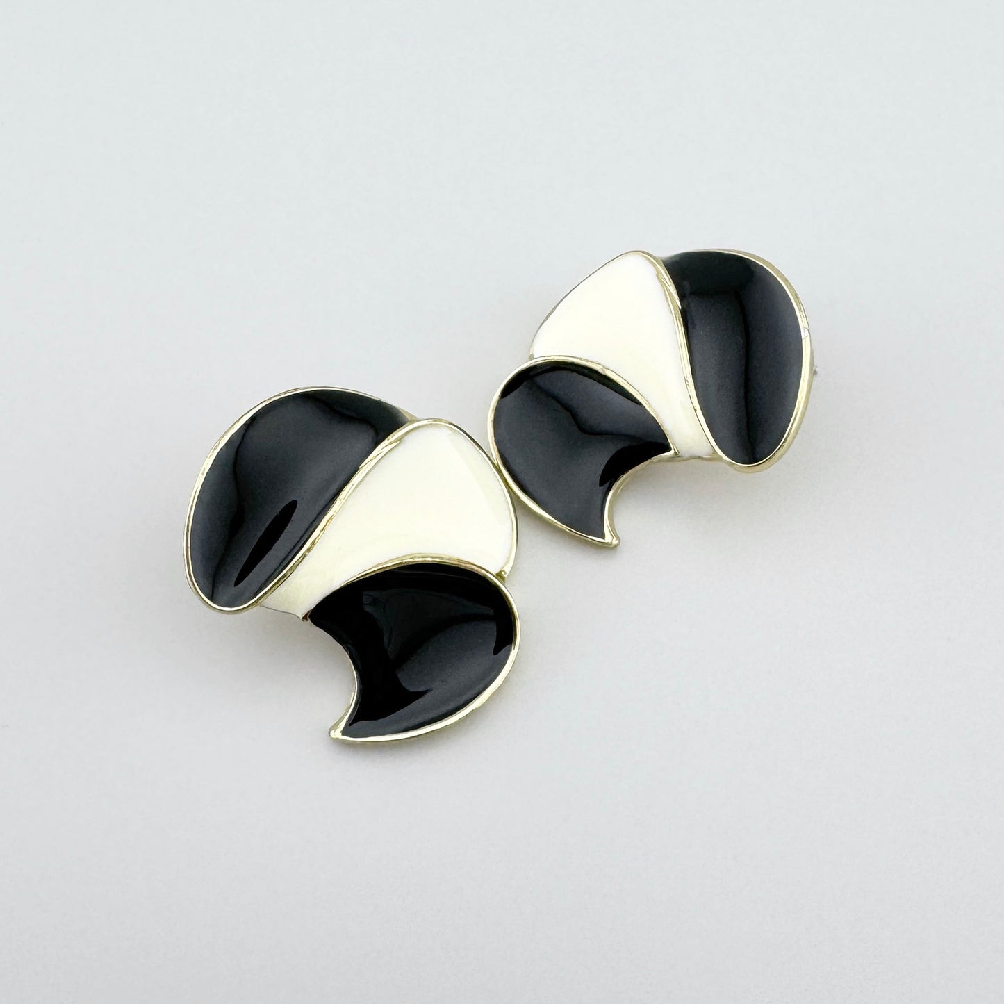 Pendientes geométricos con esmalte negro y crema y acabado dorado.