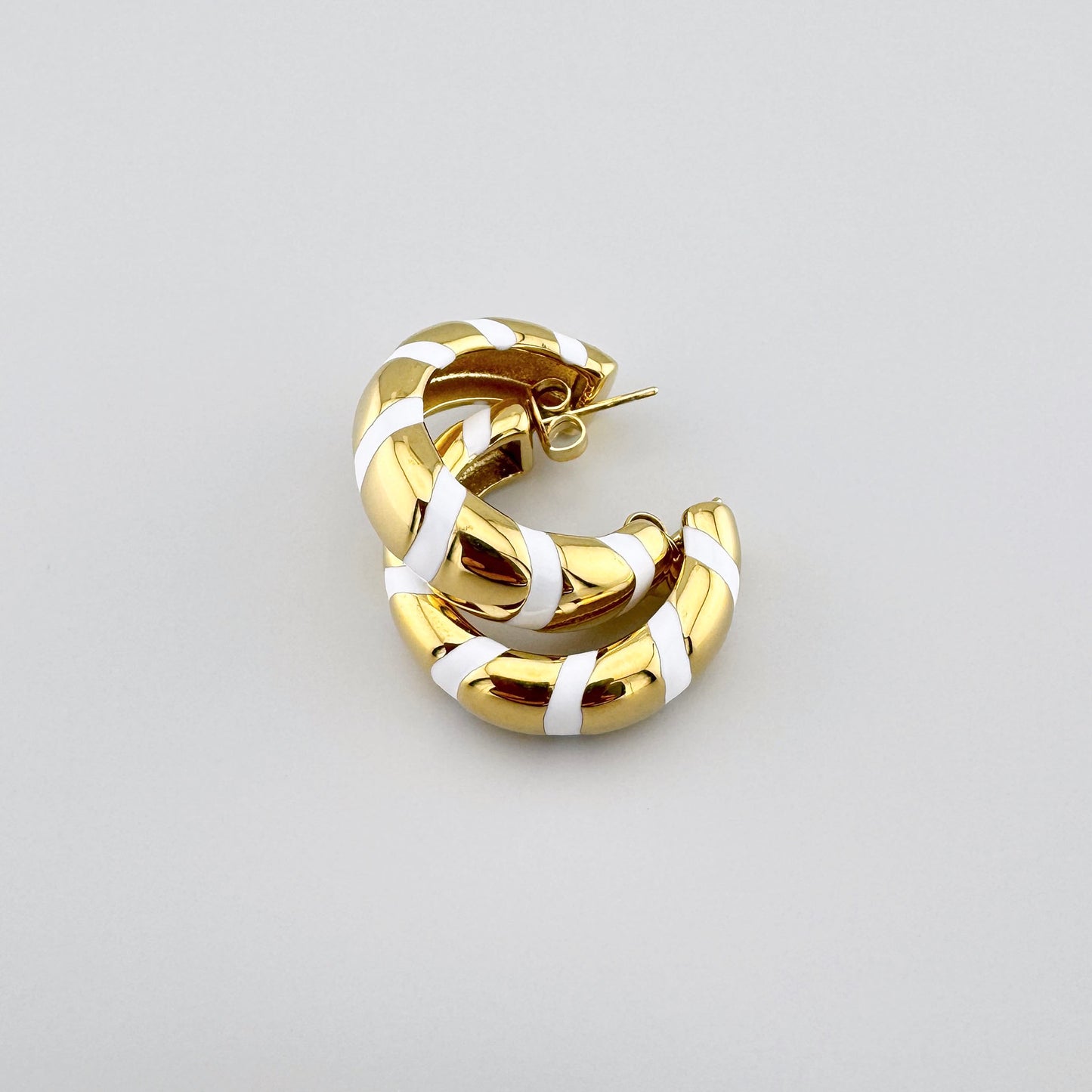 Pendientes de aro dorados con rayas de esmalte blanco, marca francesa Ikita.