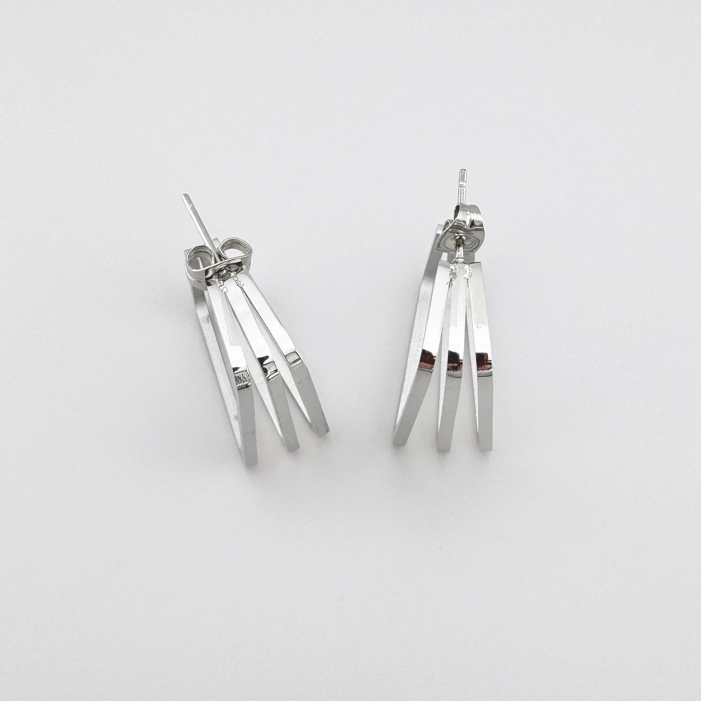 Rectangular earrings in polished silver metal with three parallel lines. Brand Maravillas.