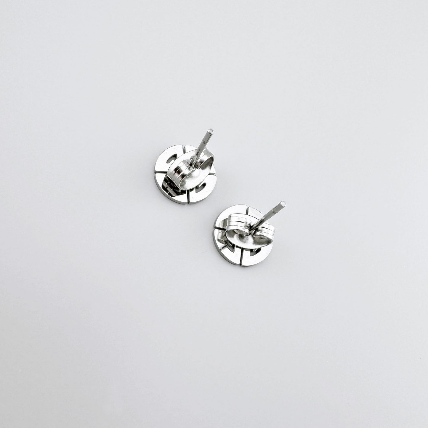 Pendientes de acero inoxidable con diseño geométrico circular.