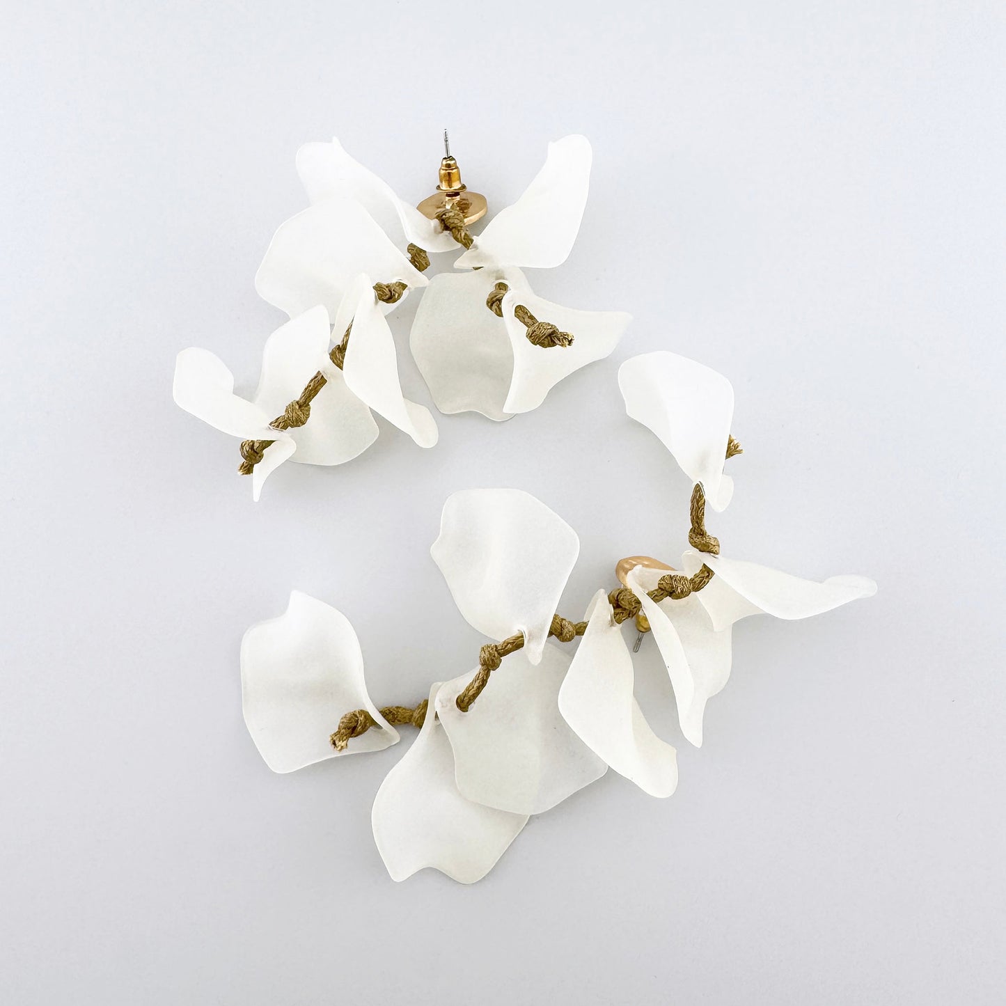 Boucles d'oreilles blanches avec pétales translucides et détails dorés, marque espagnole Sonata.