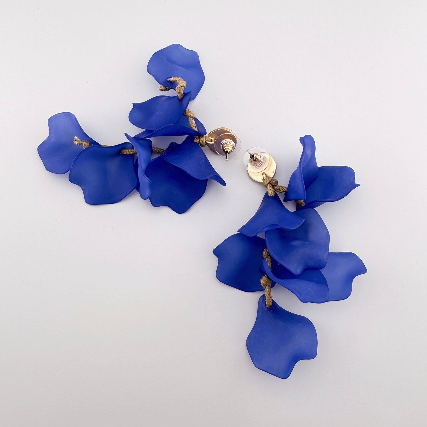 Pendientes con pétalos azules mates en una cuerda decorativa y base dorada, marca española Sonata.