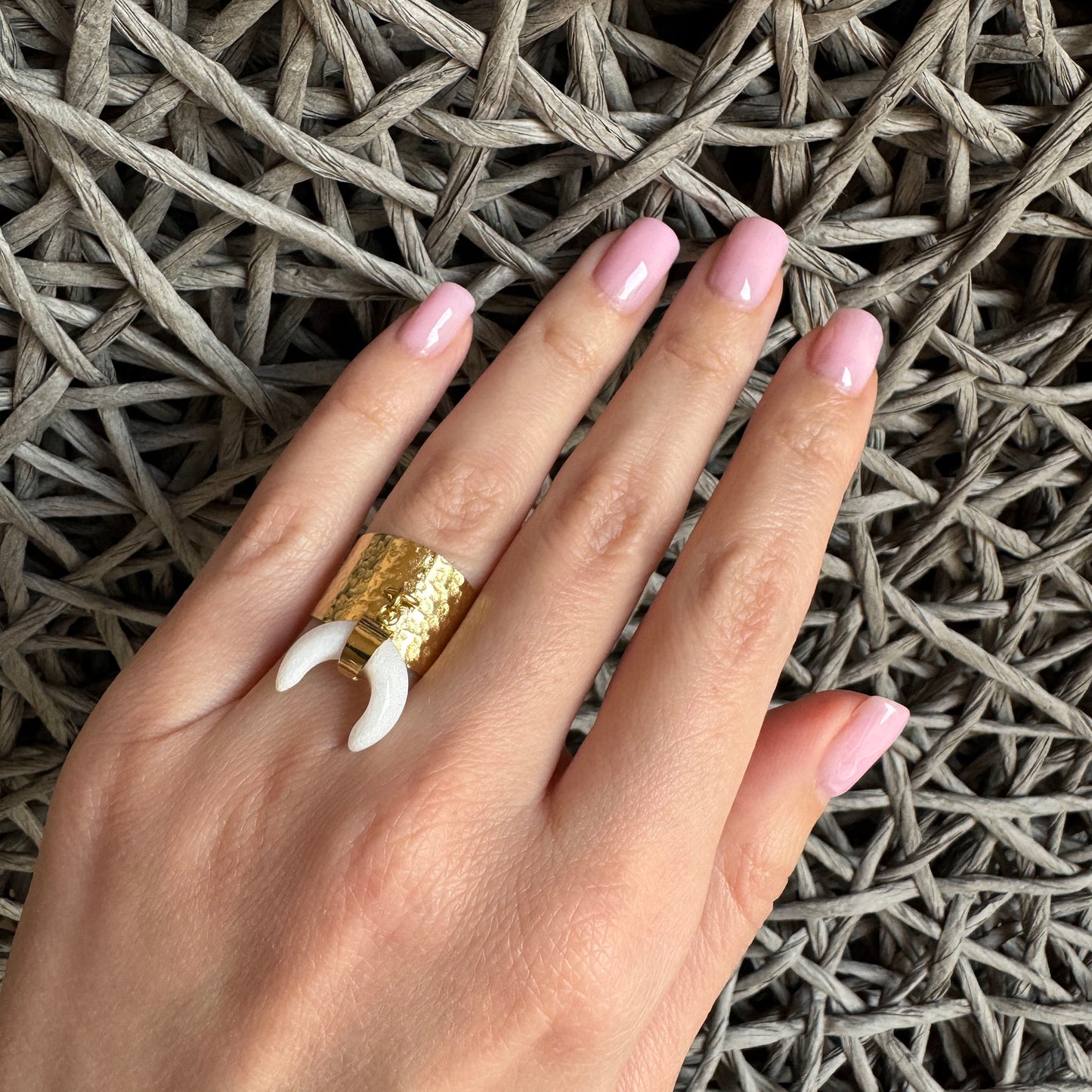 Gold-colored ring with a wide band and white crescent-shaped pendant, French brand Ikita.