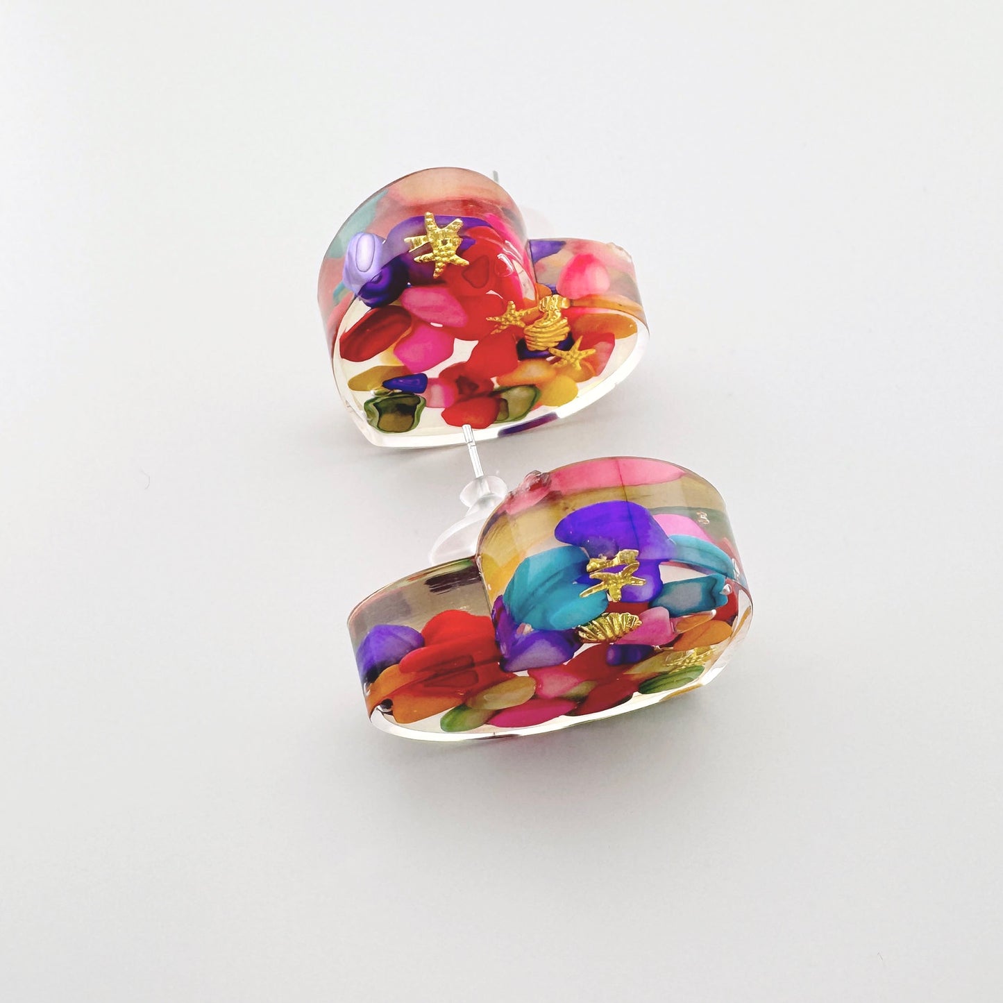 Heart-shaped earrings filled with colorful stones.
