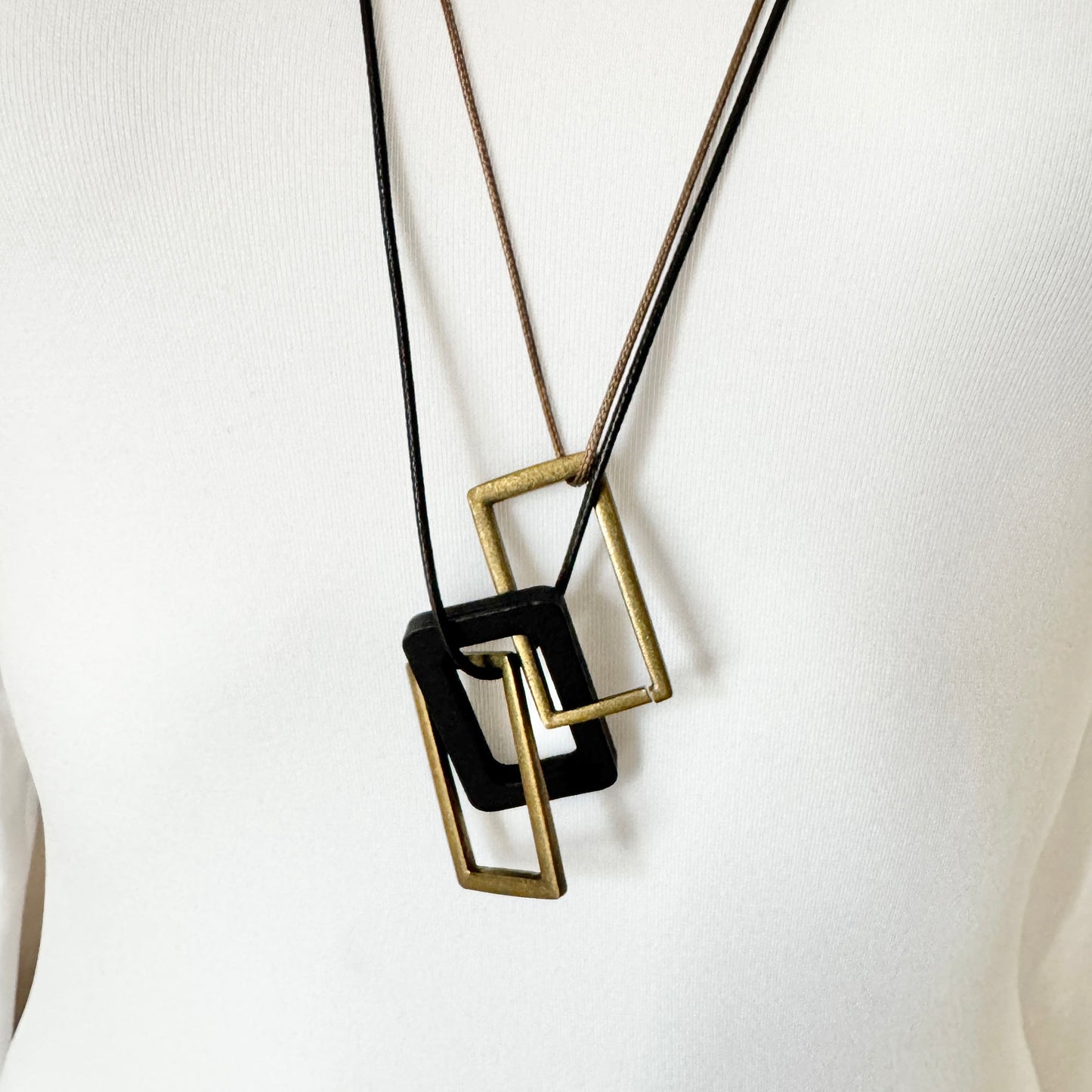 Necklace with beige and black leather cords and geometric pendants made of metal and wood, Spanish brand Sonata.