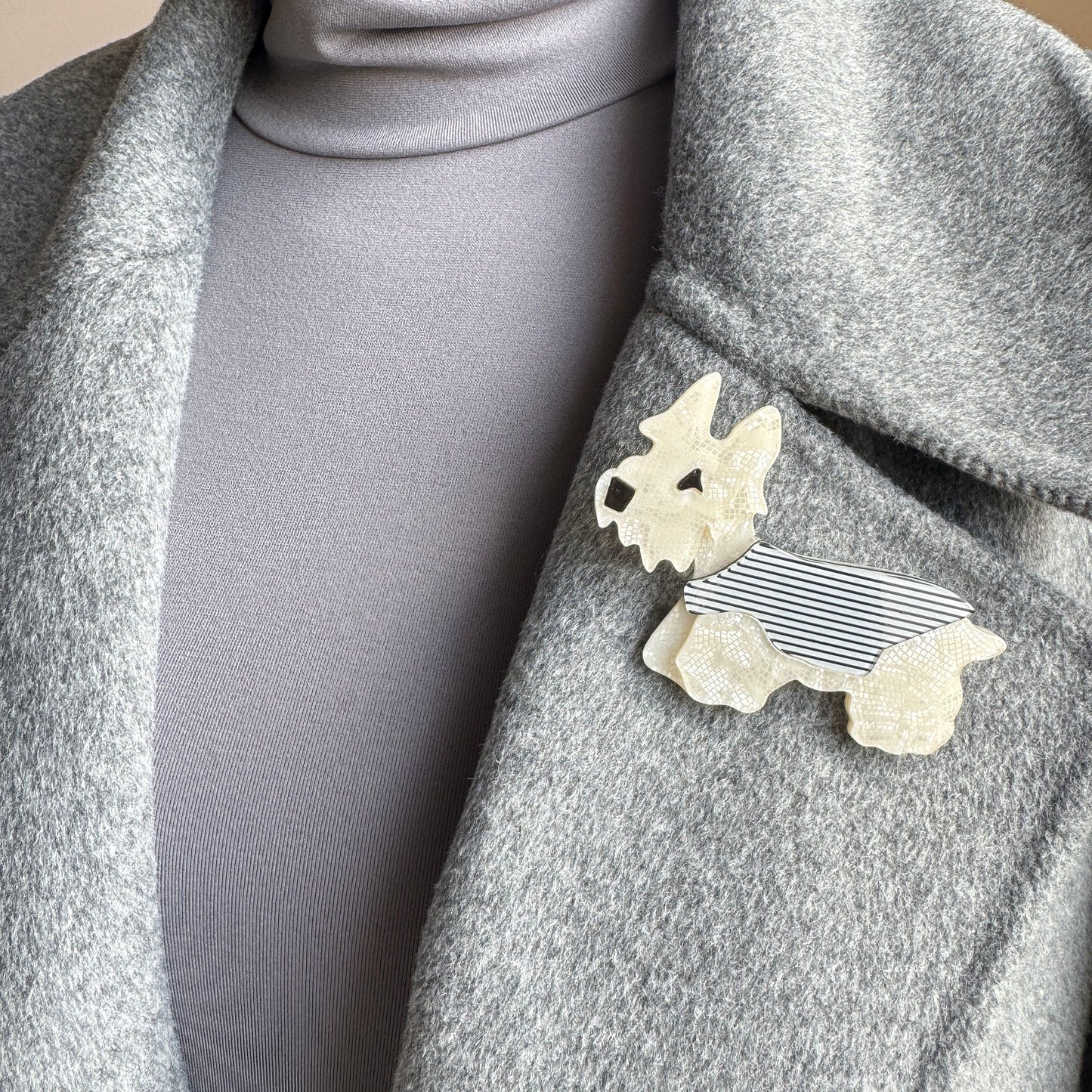 Dog-shaped brooch made of pearlescent acrylic with a mosaic texture and striped vest, Spanish brand Sonata.