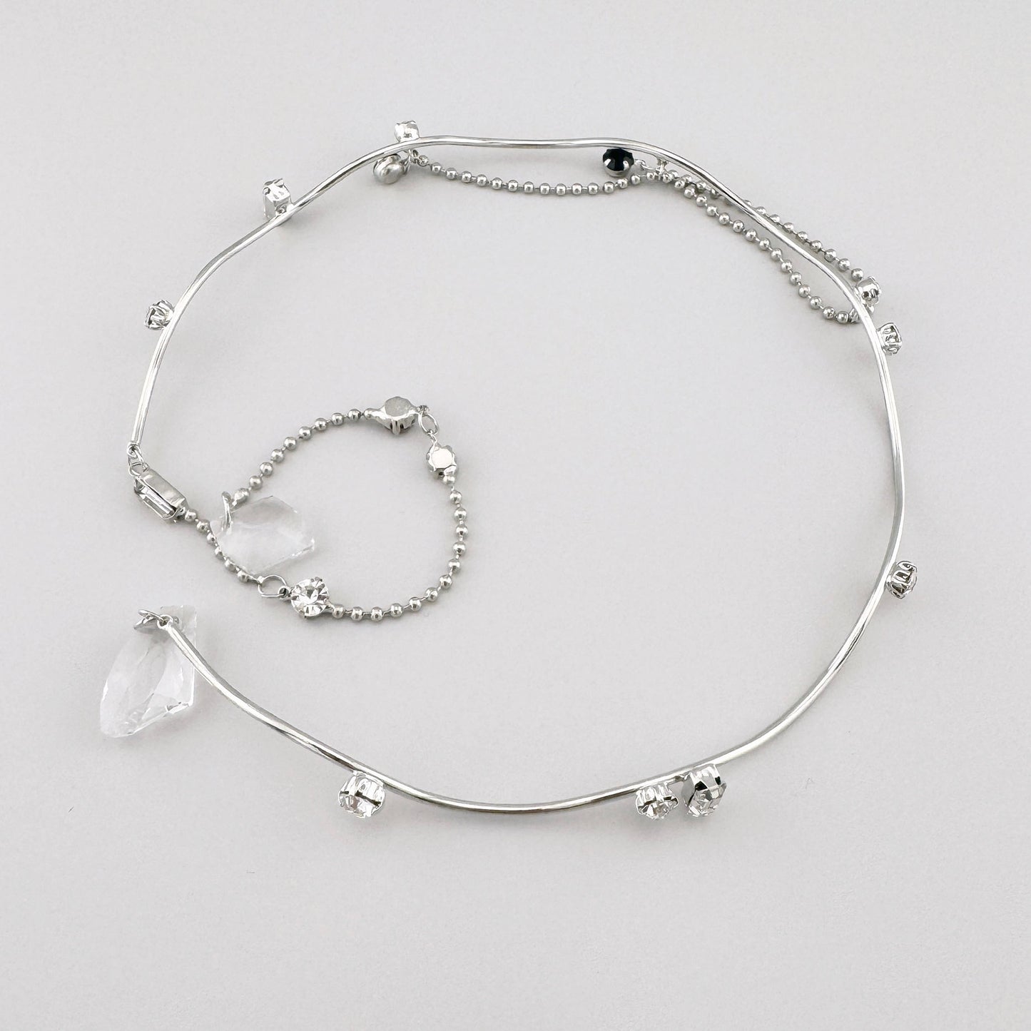 Серебристое колье с металлическими элементами, украшенное прозрачными и черными кристаллами, испанский бренд Maravillas.