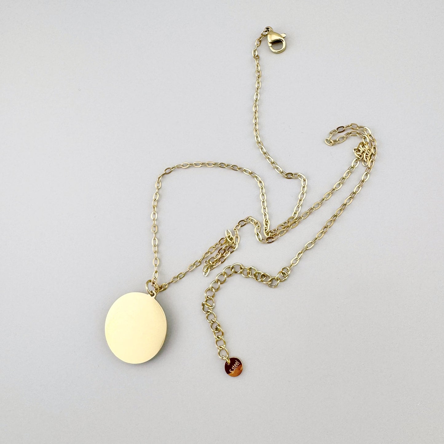 Gold-tone necklace with a medallion featuring blue enamel and a scarab motif, French brand Ikita.