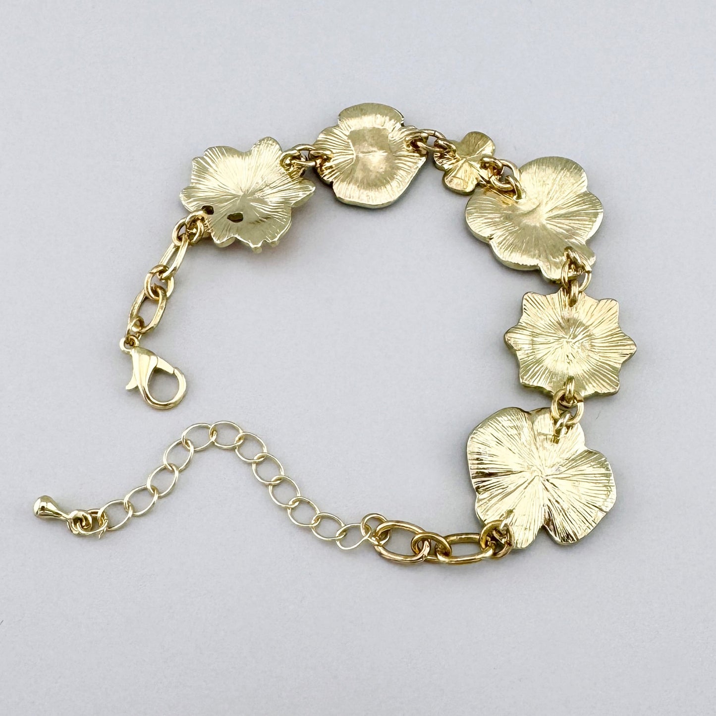 Bracelet avec des fleurs en émail colorées et une chaîne dorée.