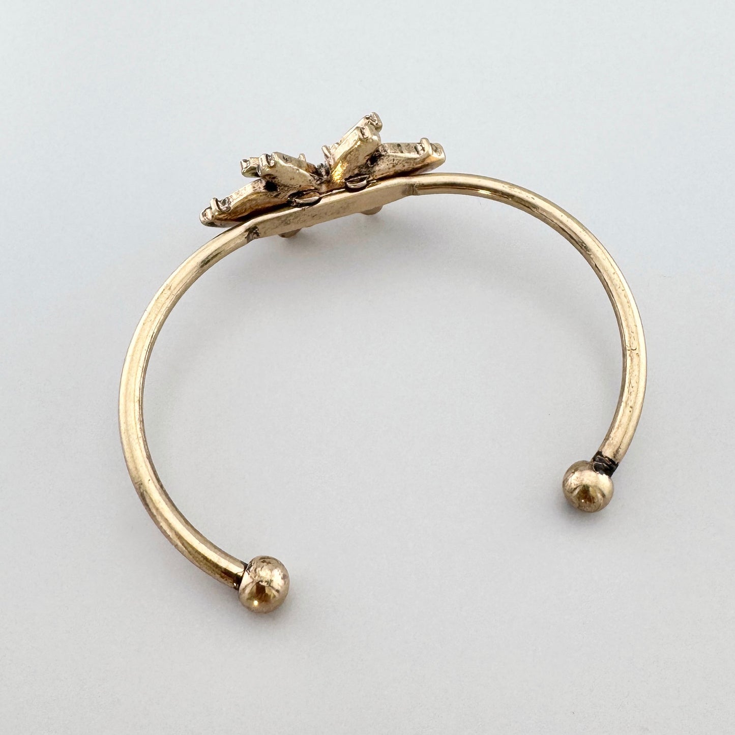 Offenes Armband in Gold mit geometrischen Kristallen.