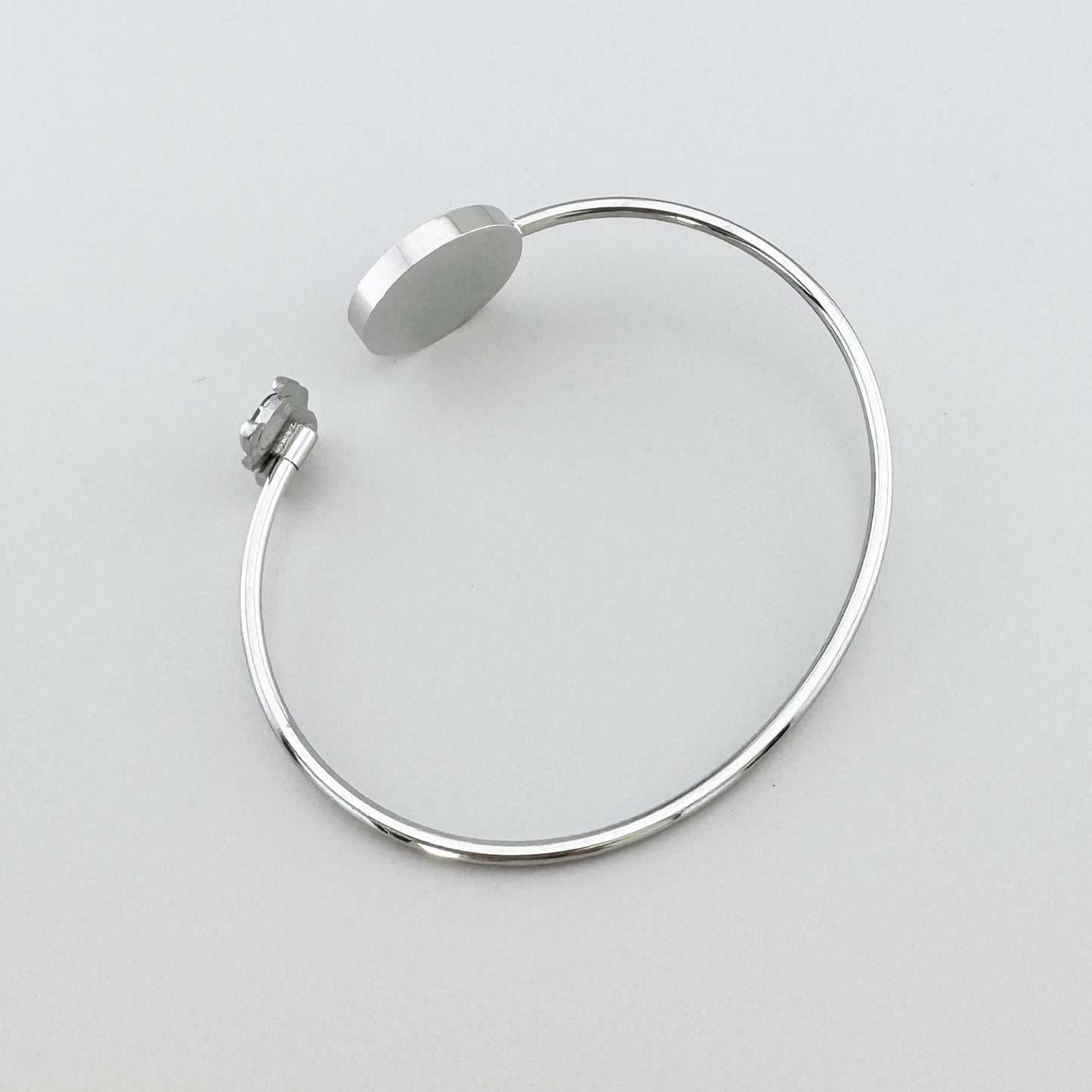 Pulsera plateada con medallón esmaltado en negro y motivo de escarabajo, marca francesa Ikita.