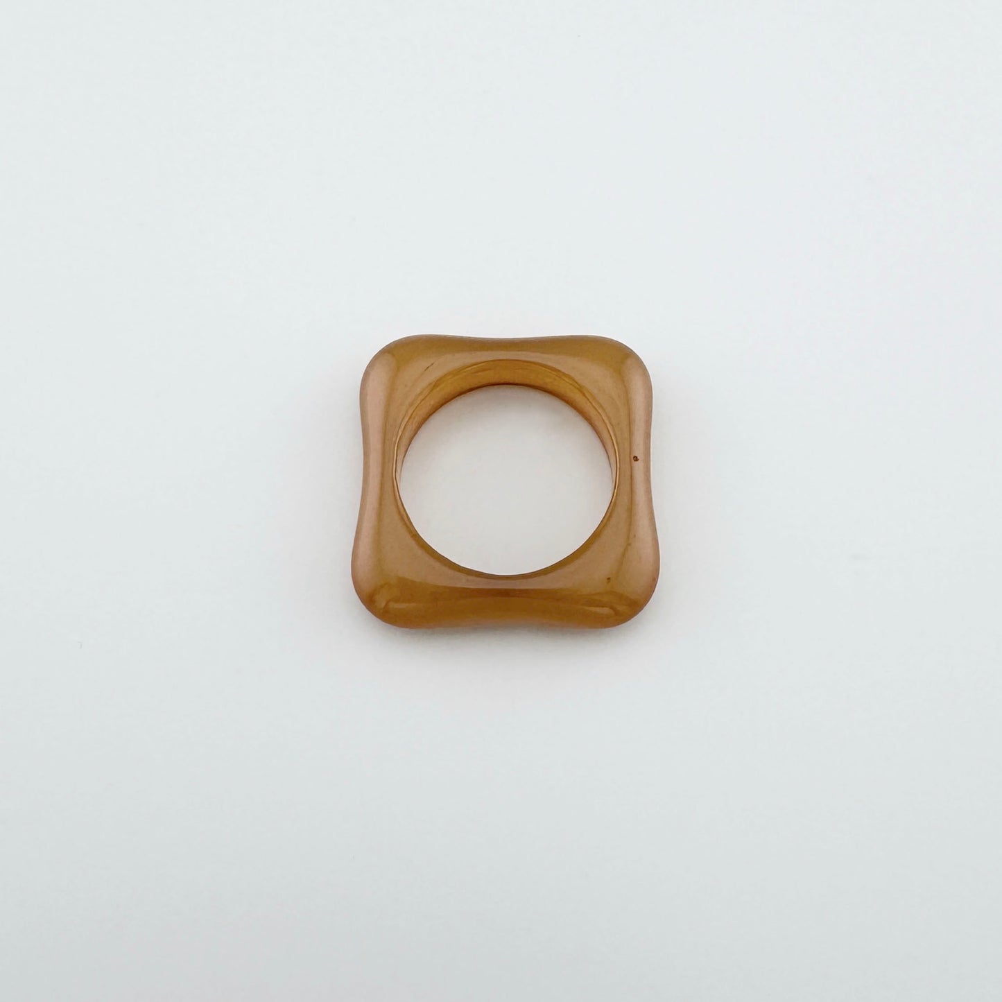 Caramel-colored plastic ring with a square shape and rounded edges, Spanish brand Sonata.