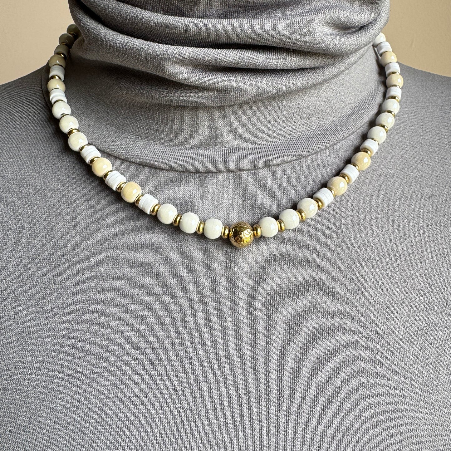 Necklace with round white and ecru ceramic beads and golden accents, French brand Ikita.