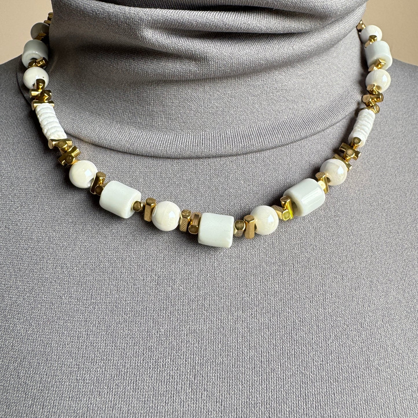 White ceramic bead necklace with golden accents, French brand Ikita.