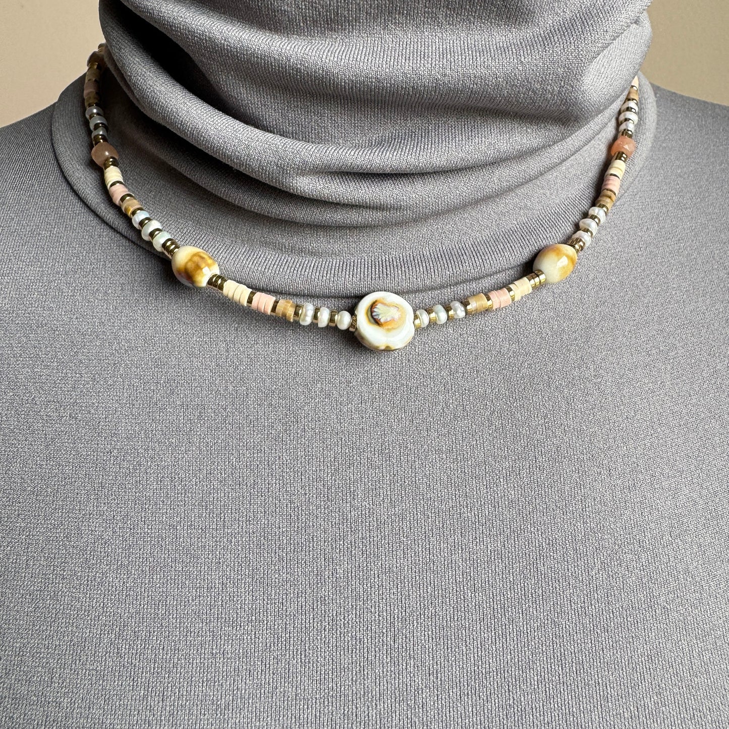 Necklace with pastel ceramic beads and a central accent, finished with gold spacers, French brand Ikita.