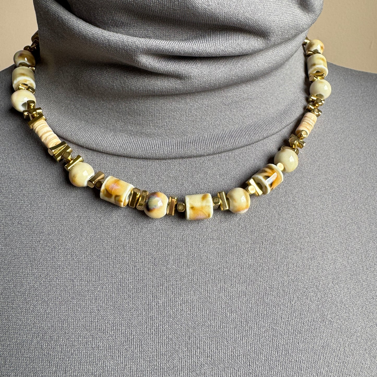 Beige ceramic bead necklace with gold-tone details, French brand Ikita.