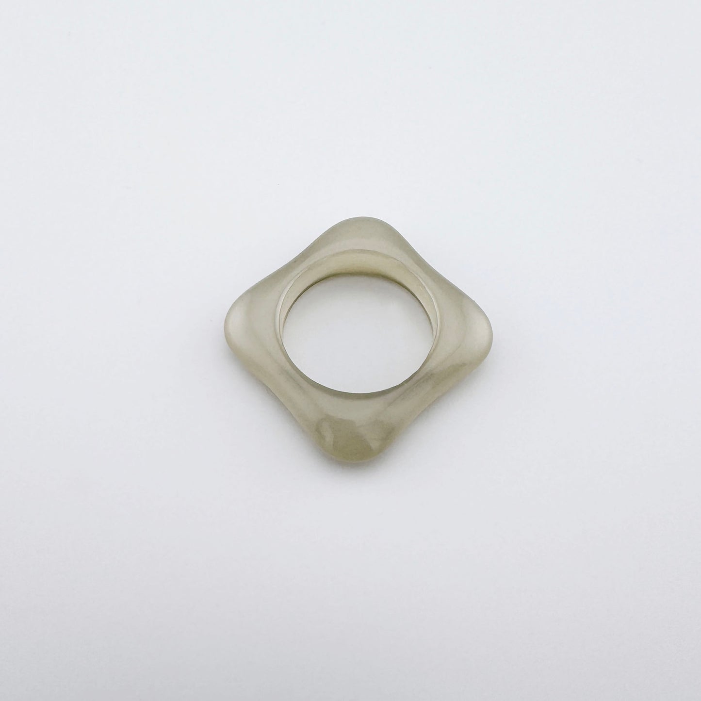 Square-shaped ring with rounded edges, made of plastic in a neutral shade, Spanish brand Sonata.