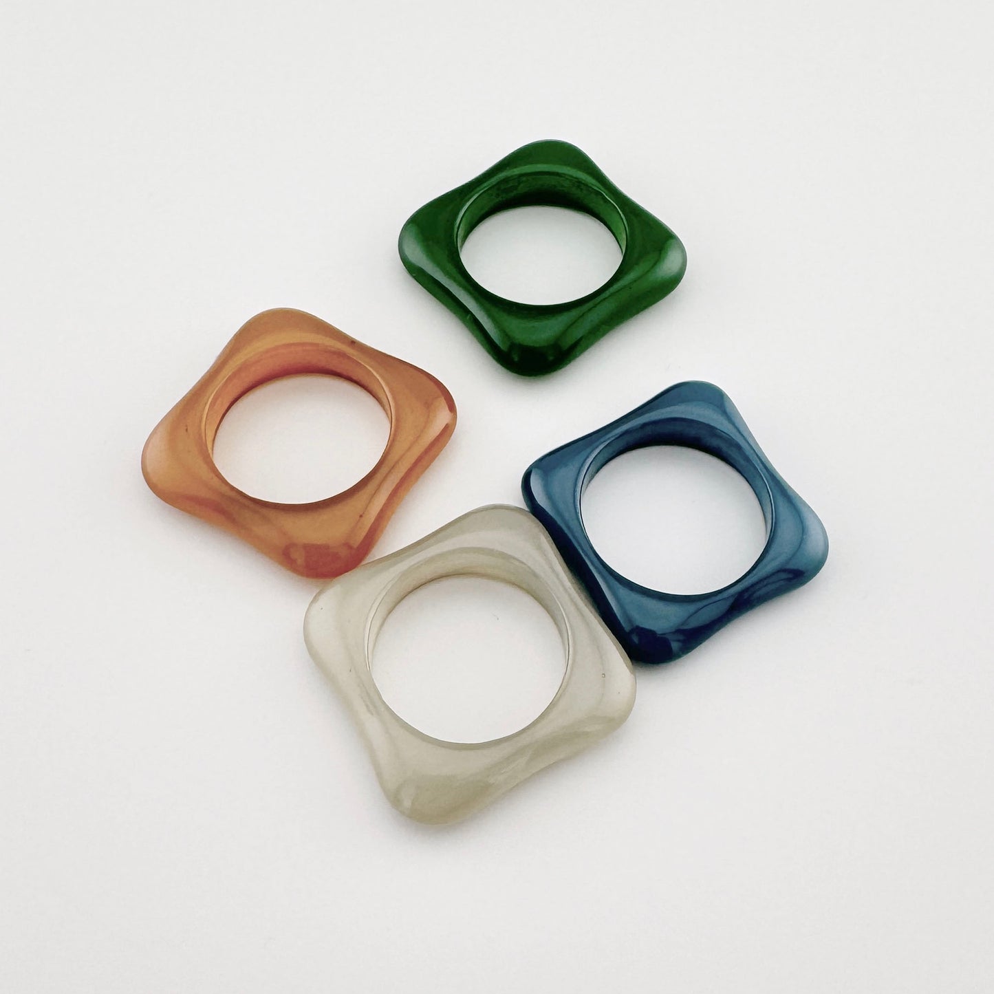 Quadratischer Ring mit abgerundeten Kanten, aus Kunststoff in neutralem Farbton, spanische Marke Sonata.