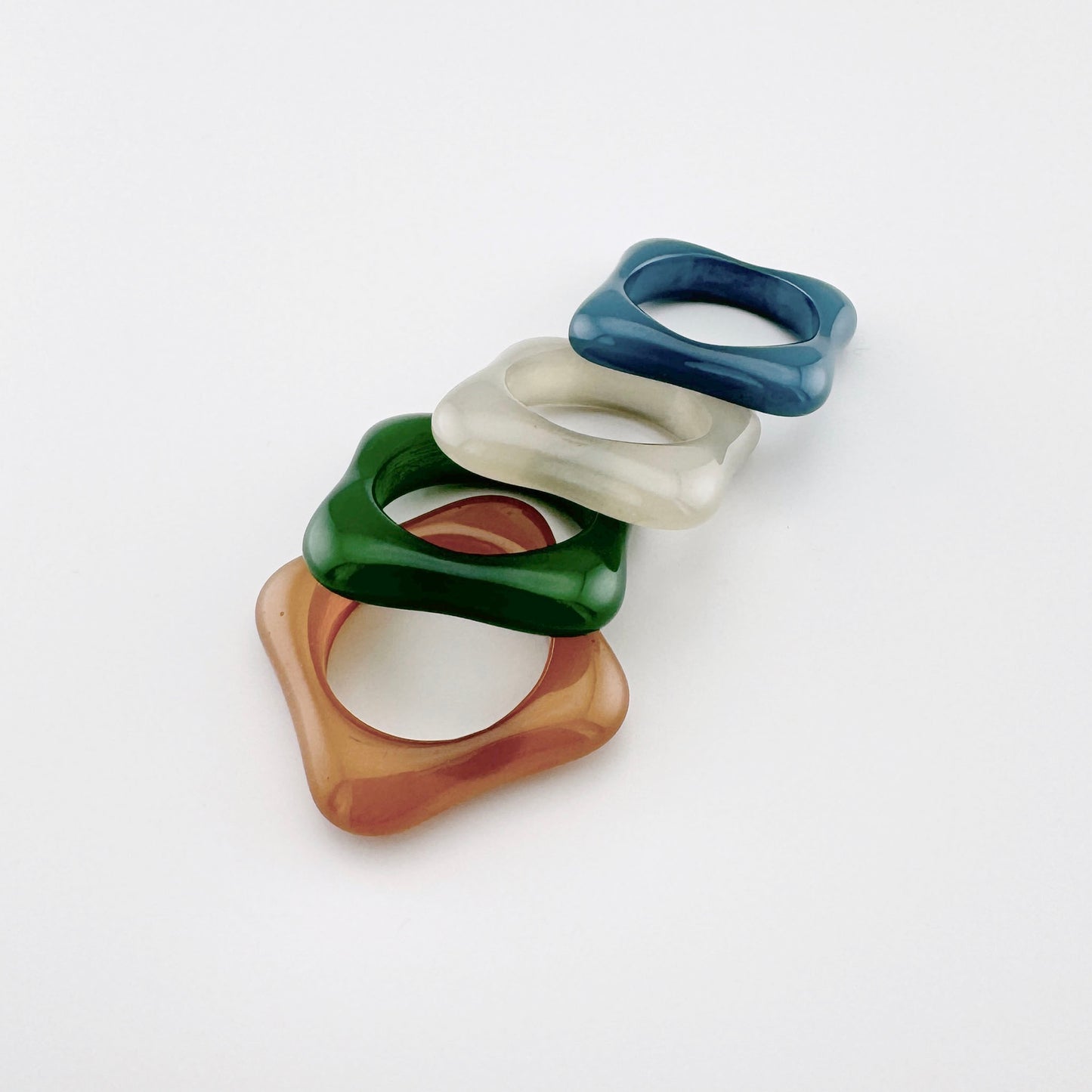 Anillo de forma cuadrada con bordes redondeados, hecho de plástico en un tono neutro, marca española Sonata.