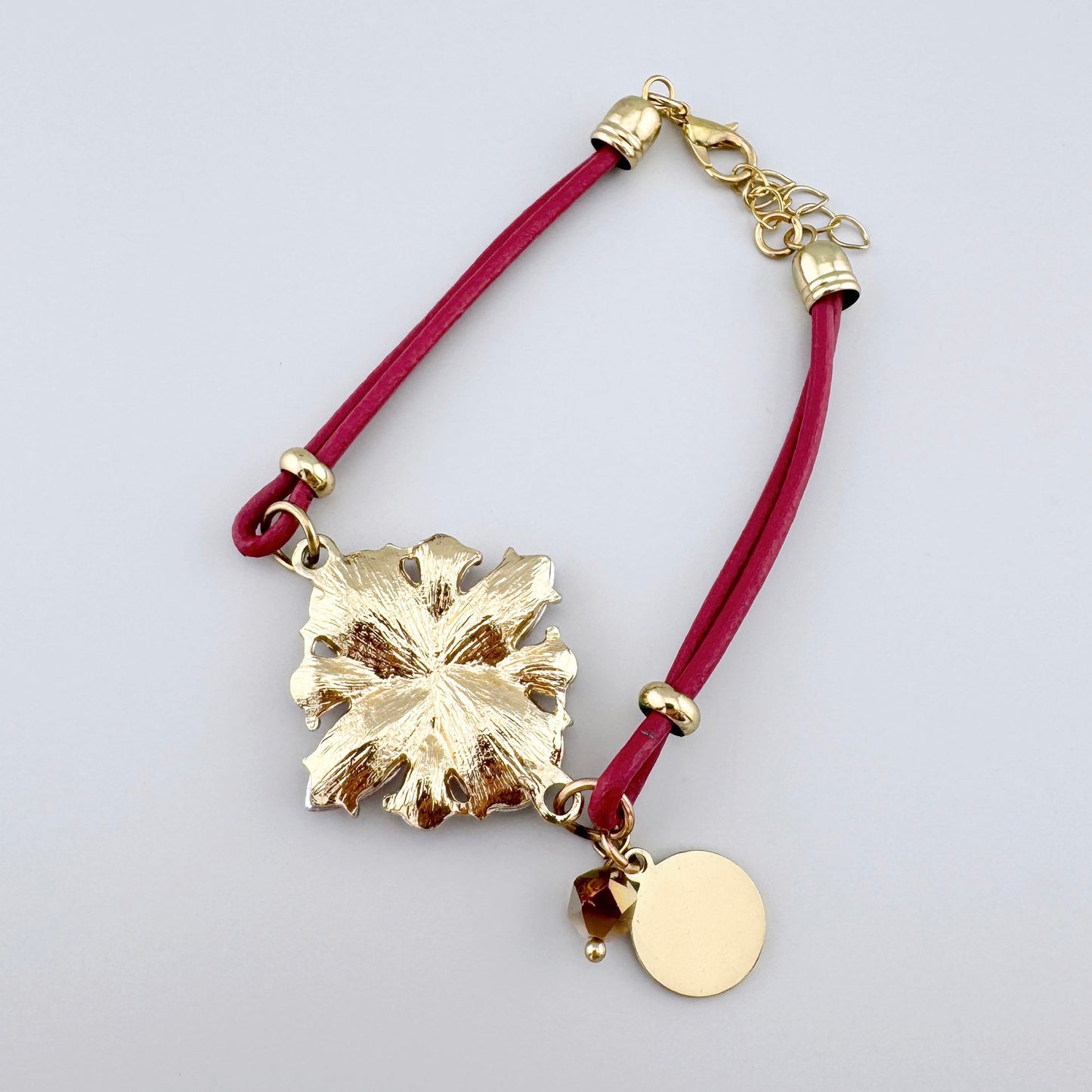 Pulsera con correa y cristales en forma de flor rosa.