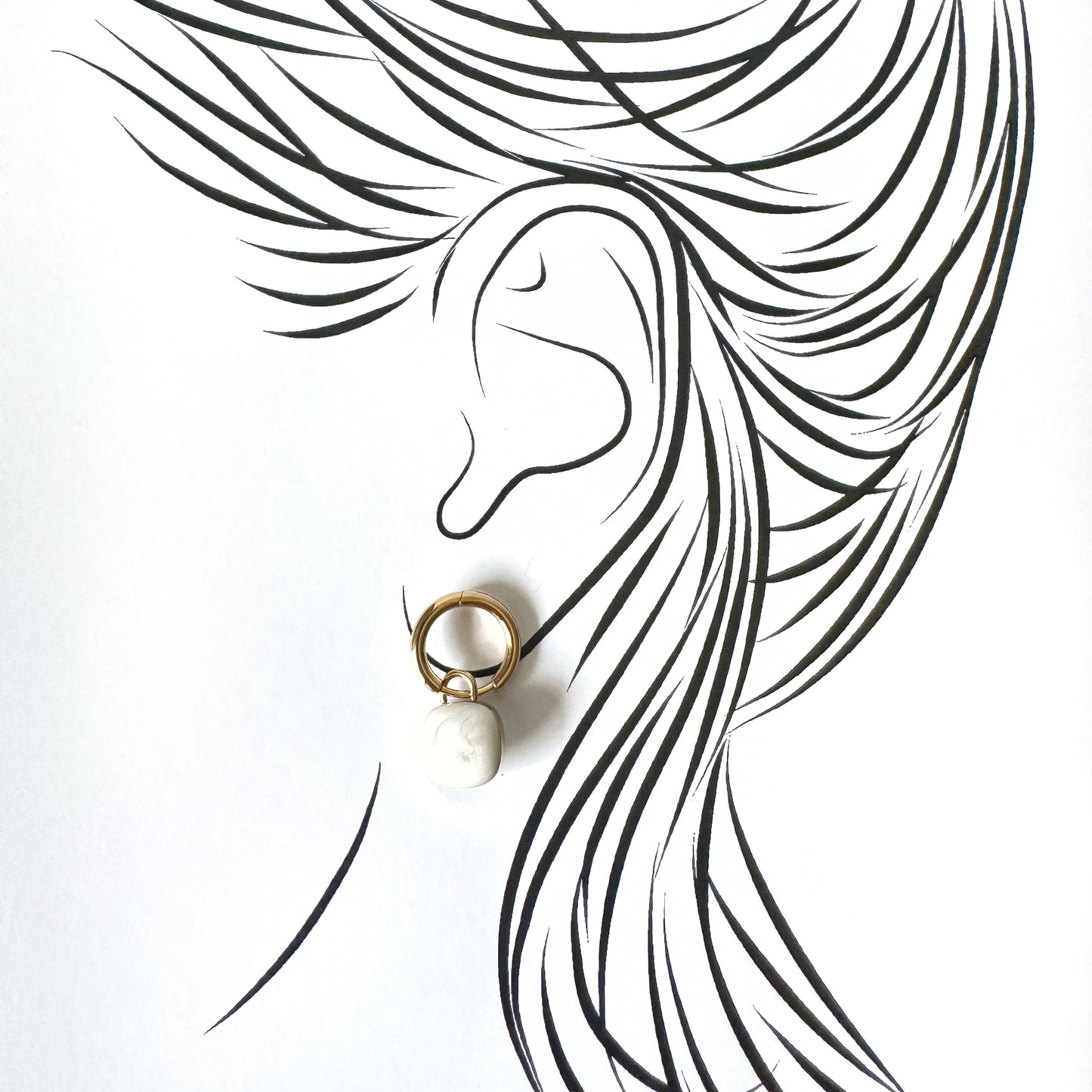 Gold hoop earrings with alabaster white porcelain charms, French brand Cannelle.