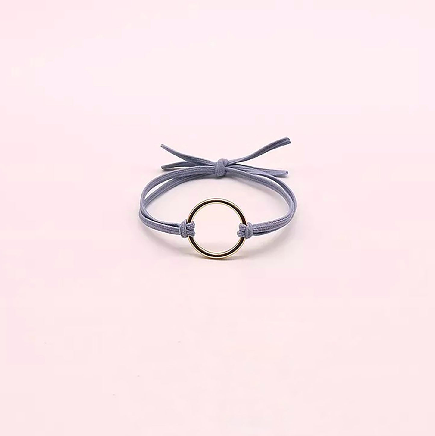 Light blue hair tie with a decorative gold-tone ring.
