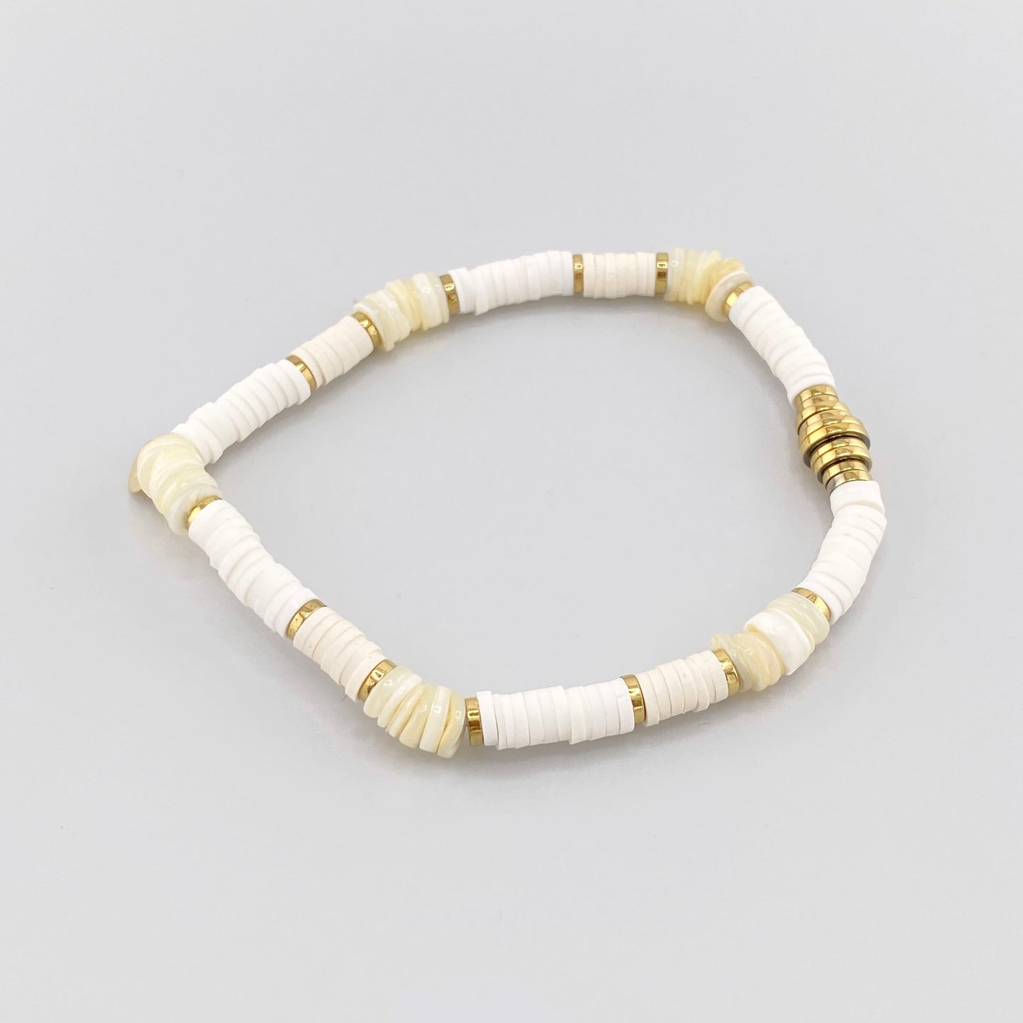 Pulsera elástica con cuentas blancas y detalles dorados, marca francesa IRL.