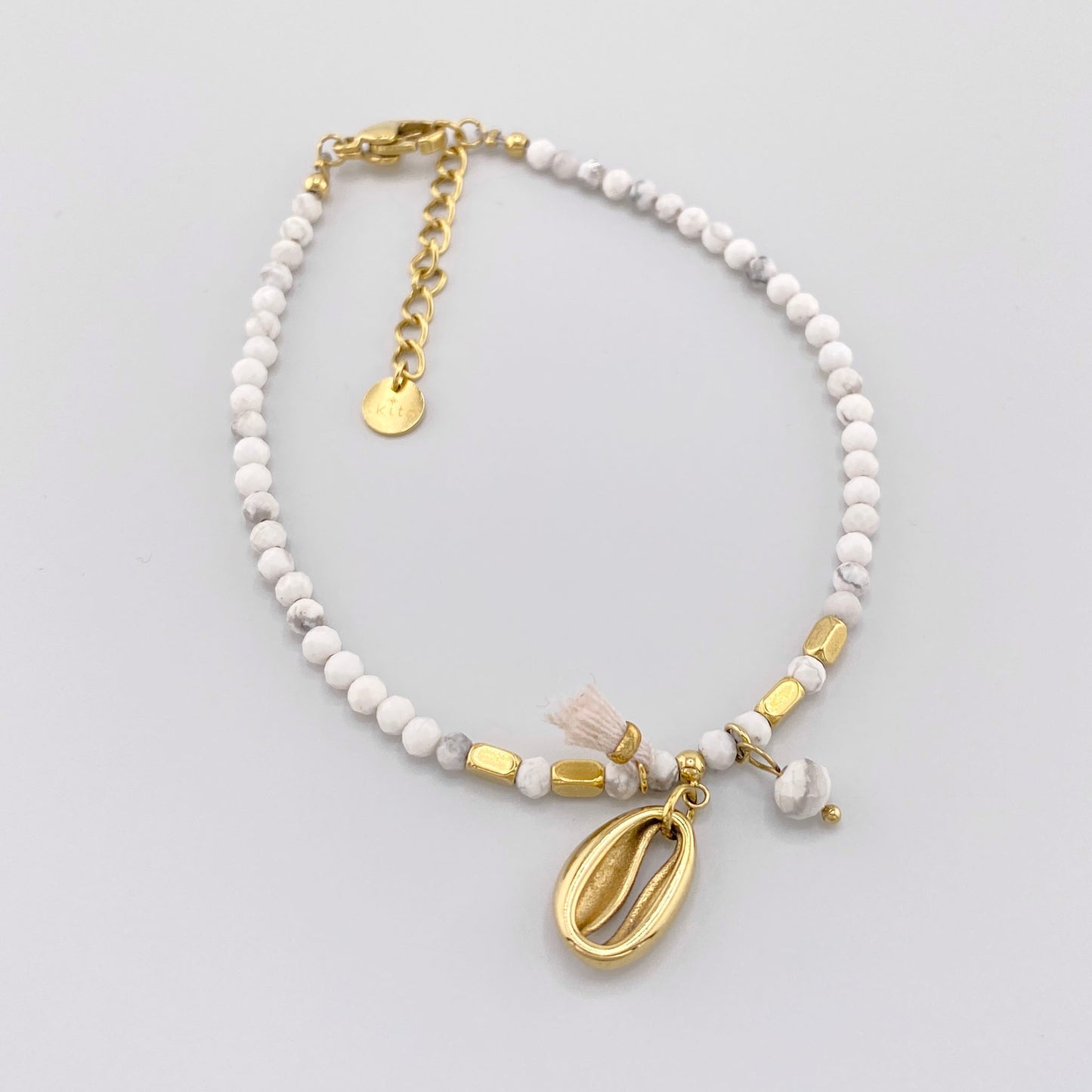 Howlith-Armband mit vergoldeten Elementen und einer muschelförmigen Anhänger, französische Marke Ikita.